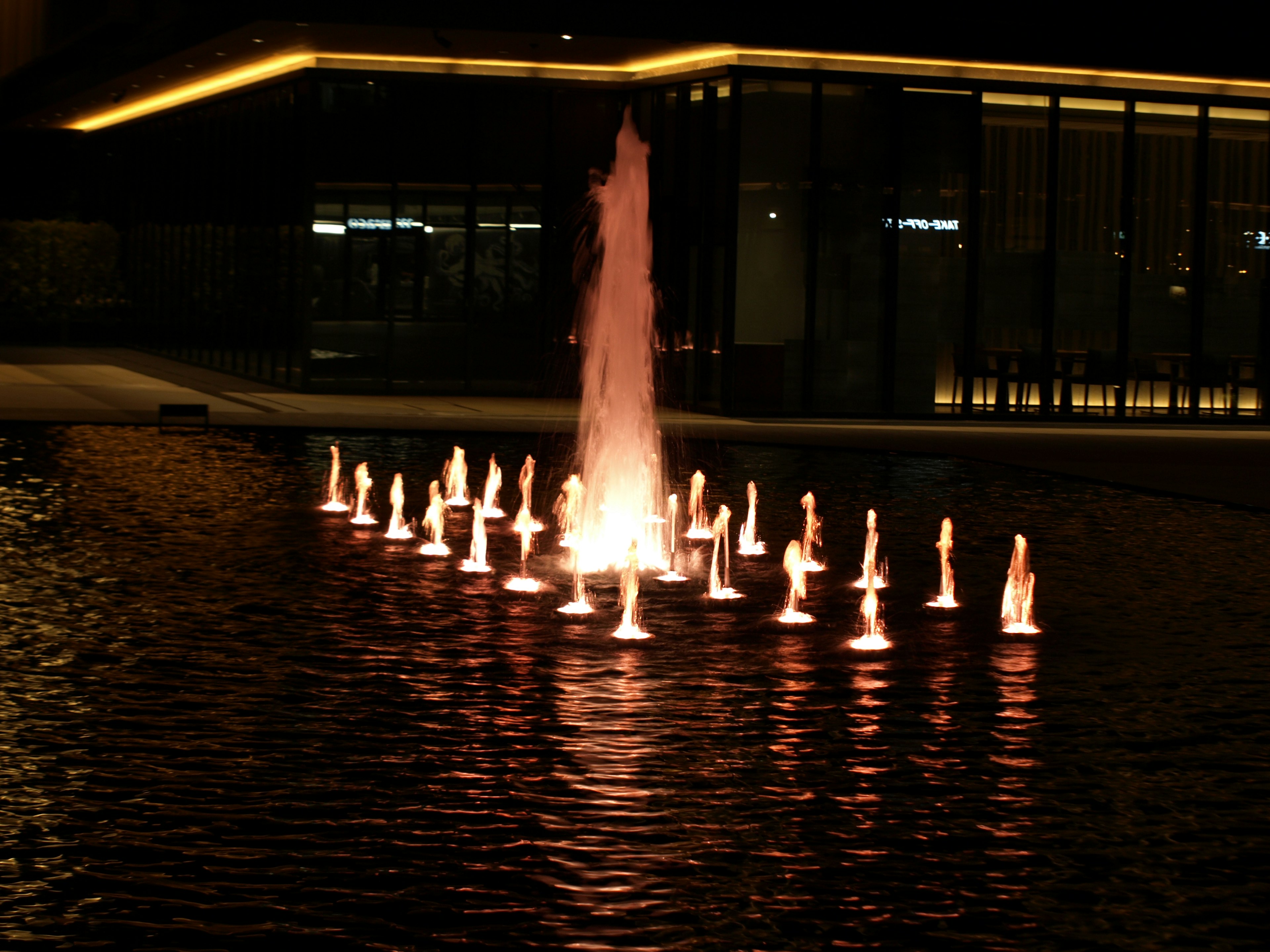 Illuminated fountain with surrounding lights at night