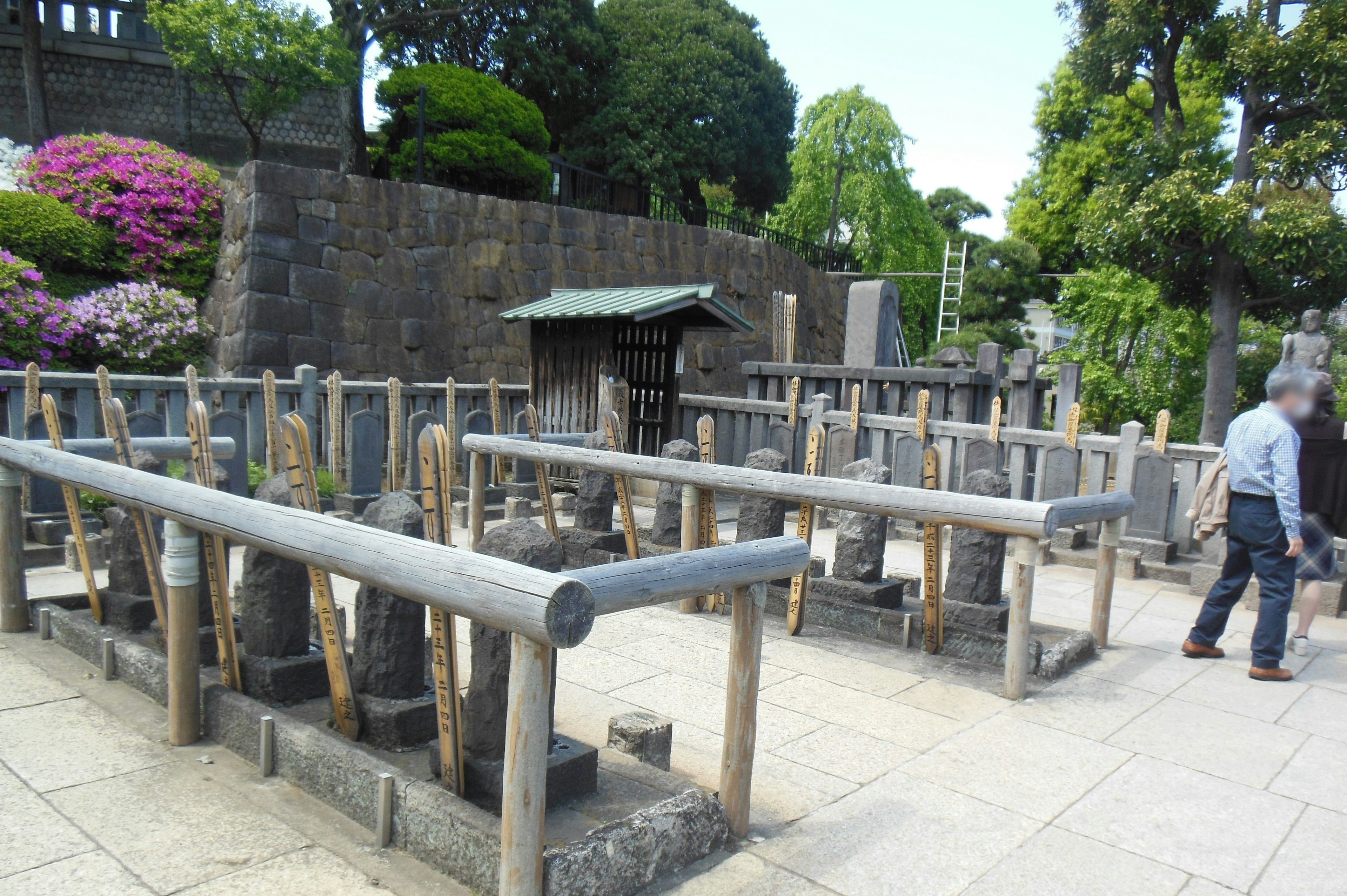 Escena de jardín sereno con esculturas de piedra y un estanque de agua de bambú