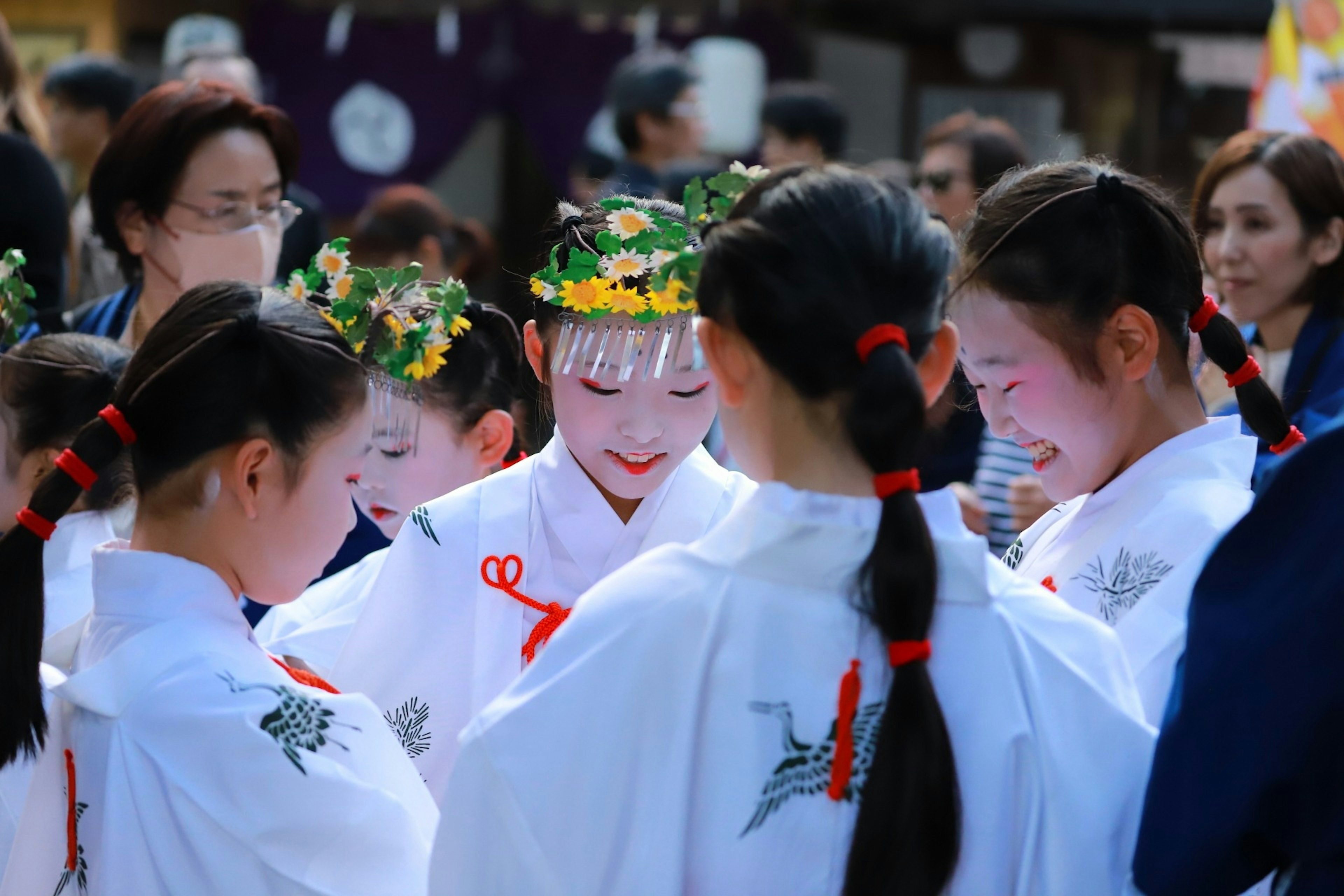 Young women in festival attire gathering and smiling while talking