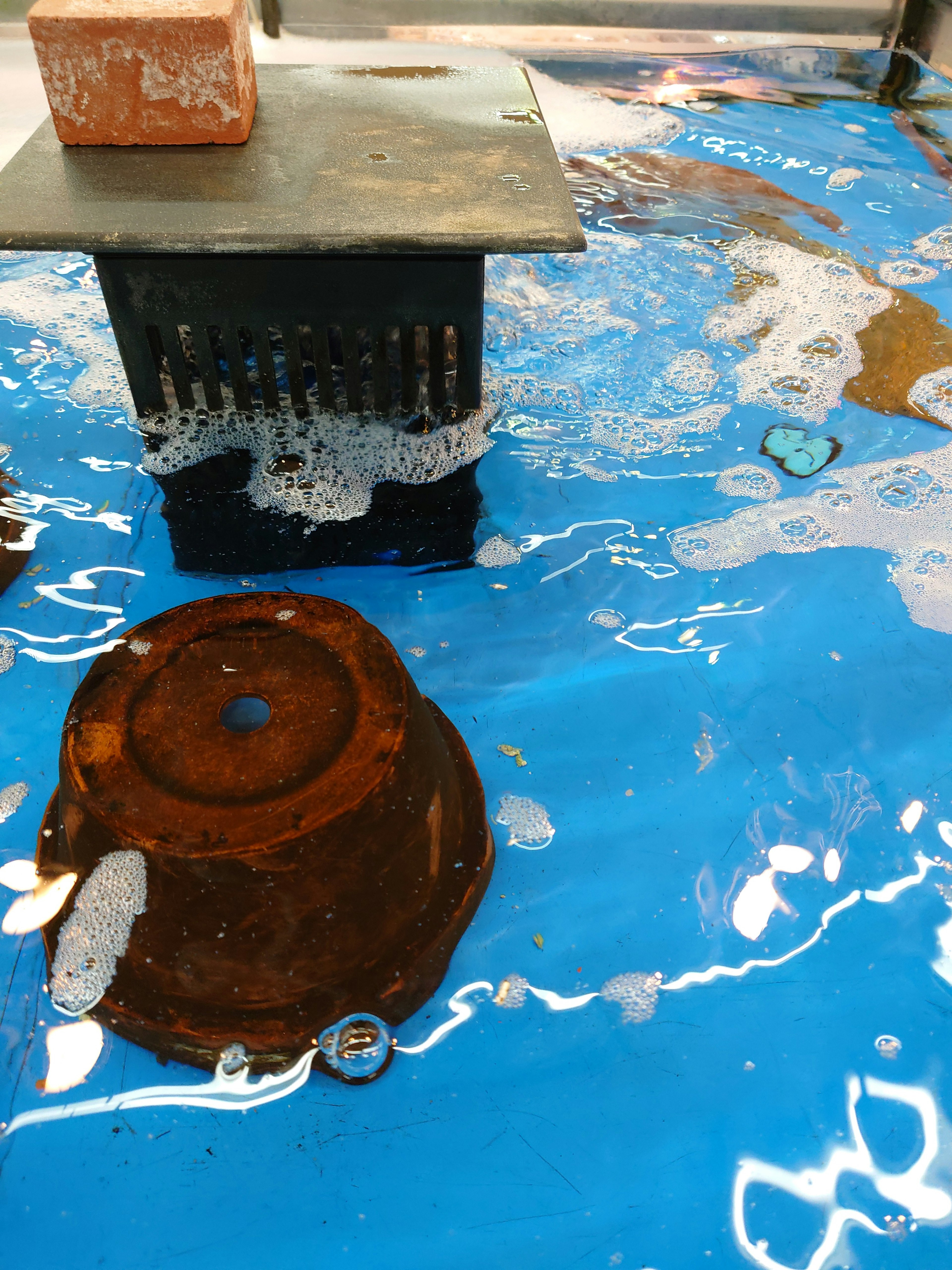 Conteneur rouillé flottant sur l'eau avec des bulles