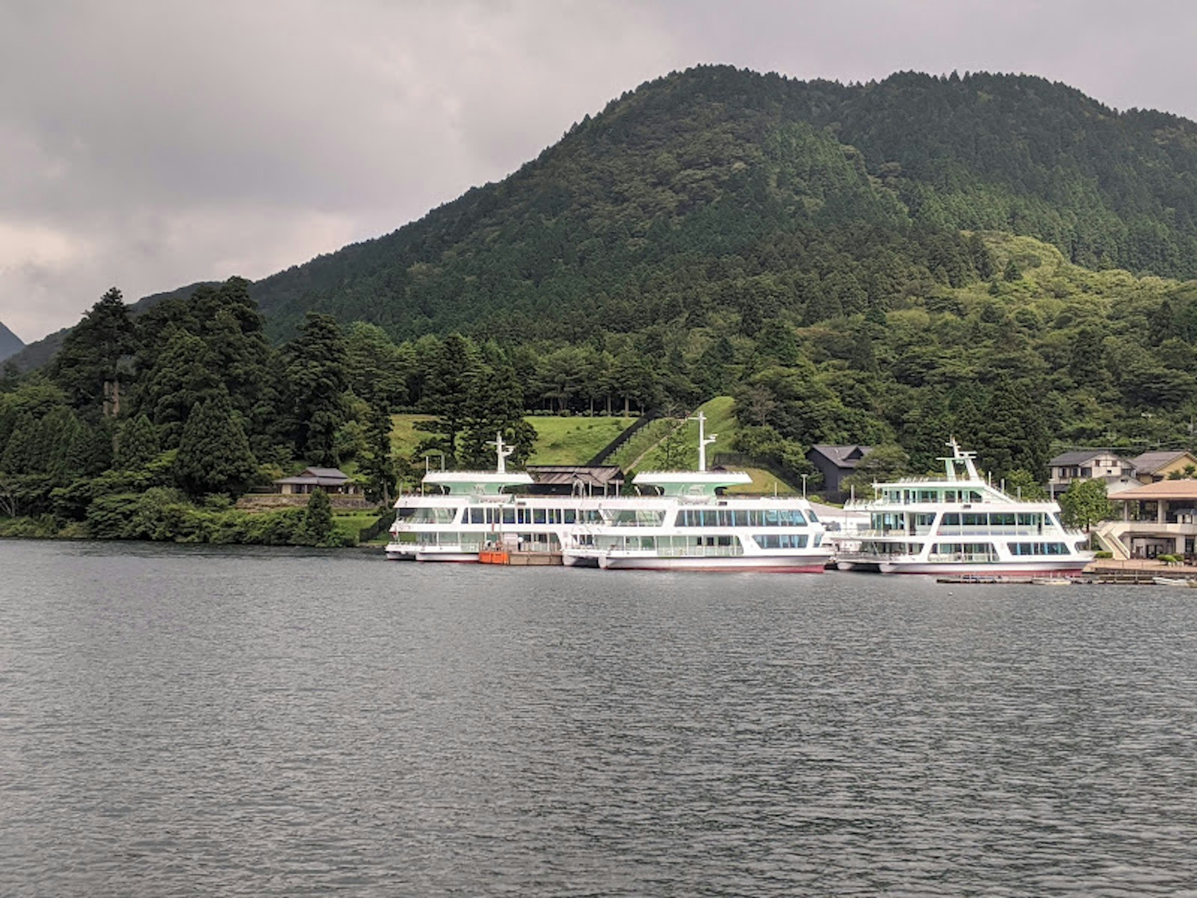 湖に浮かぶ観光船と緑の山々