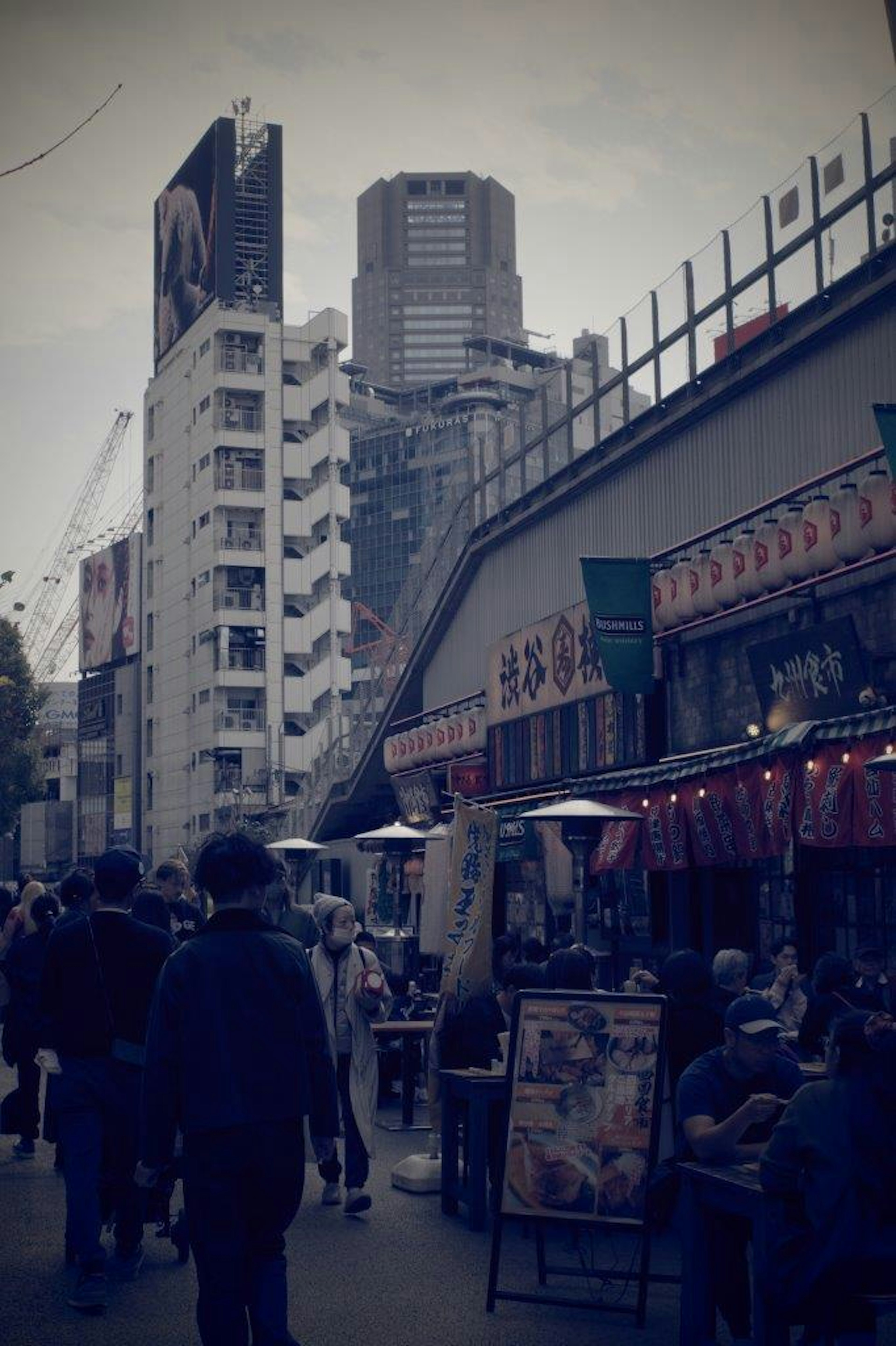 A bustling street scene with people walking and food stalls