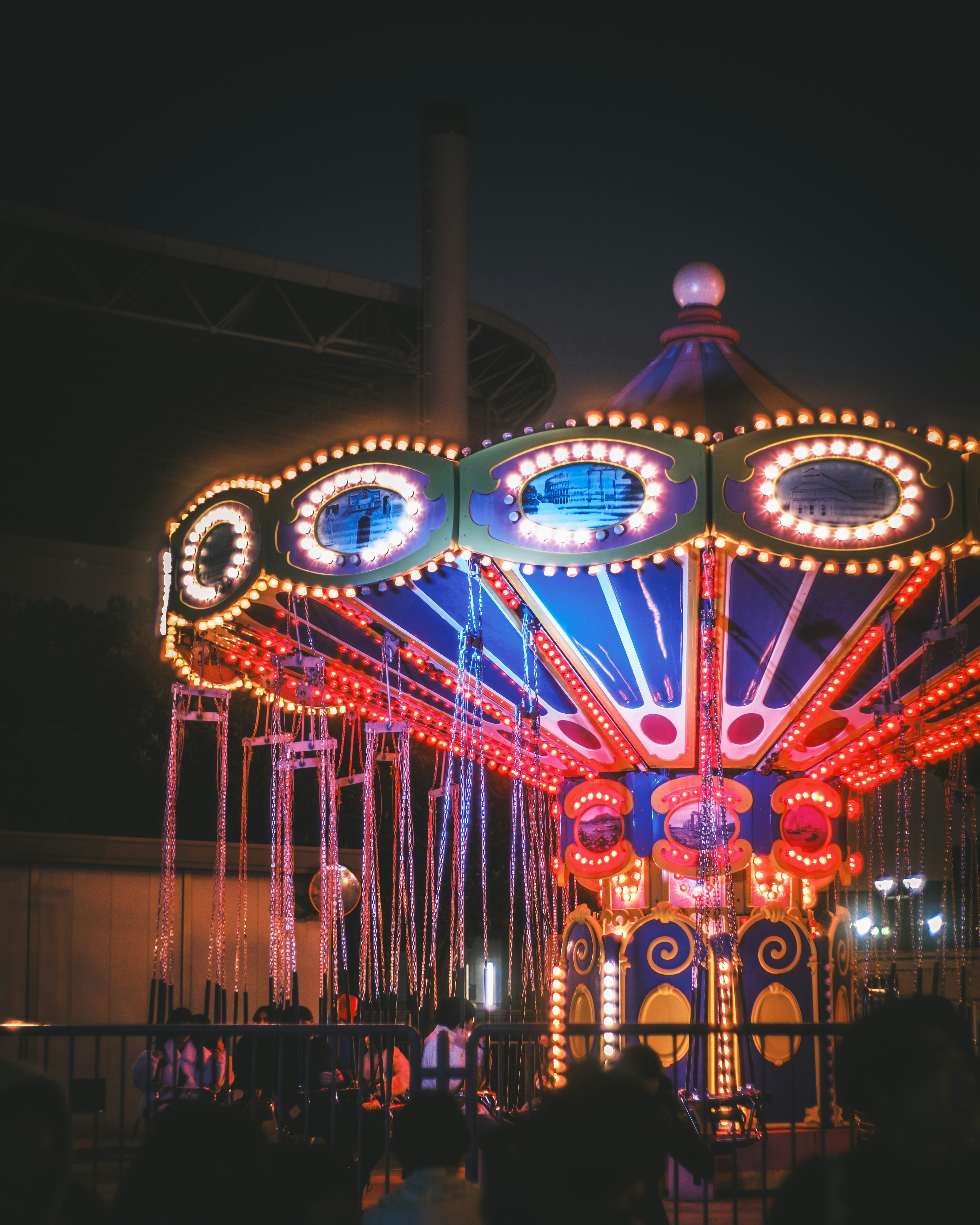 Kendaraan carousel berwarna cerah yang diterangi di malam hari