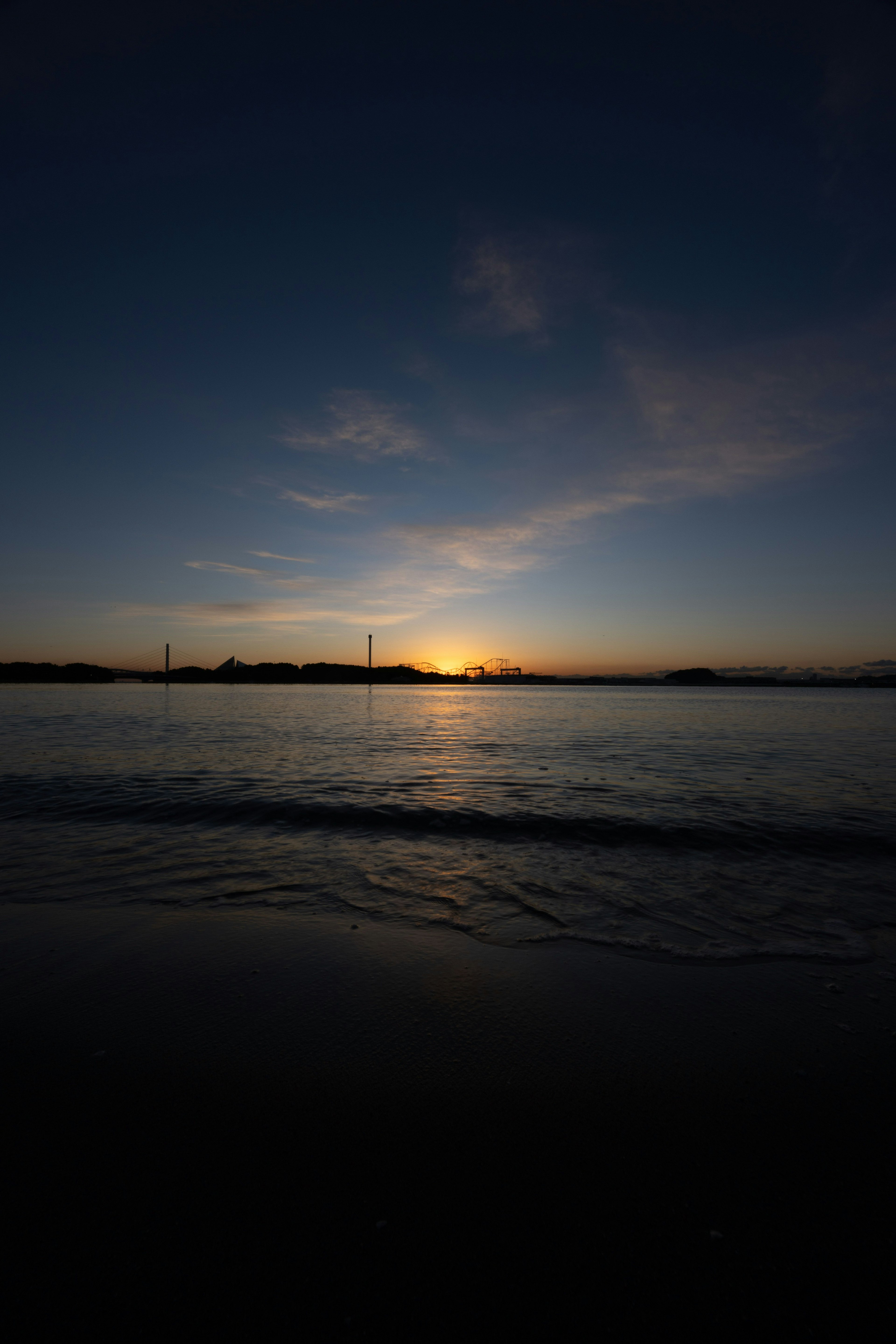 海の水平線に沈む夕日と青い空のグラデーション