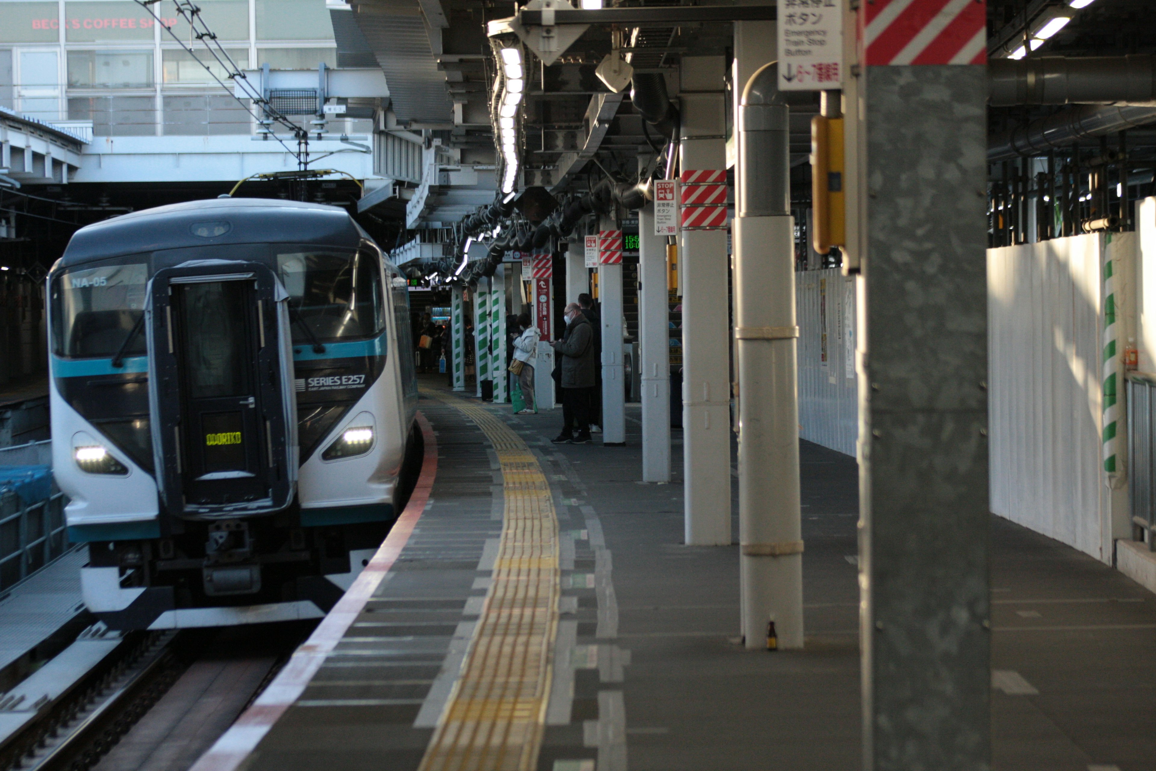 駅のプラットフォームに停車中の電車と周囲の構造物