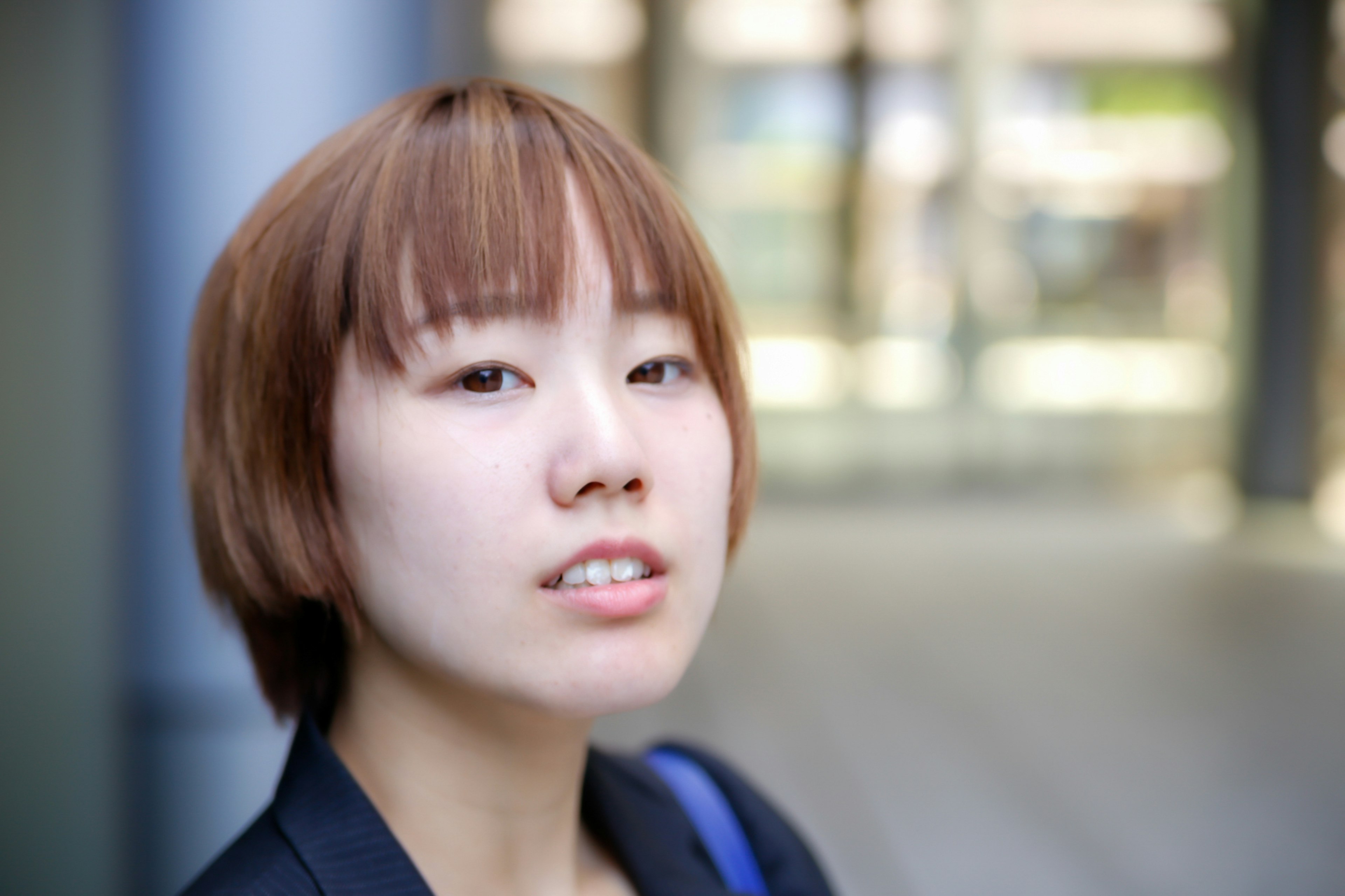 Jeune femme regardant la caméra avec un arrière-plan urbain flou