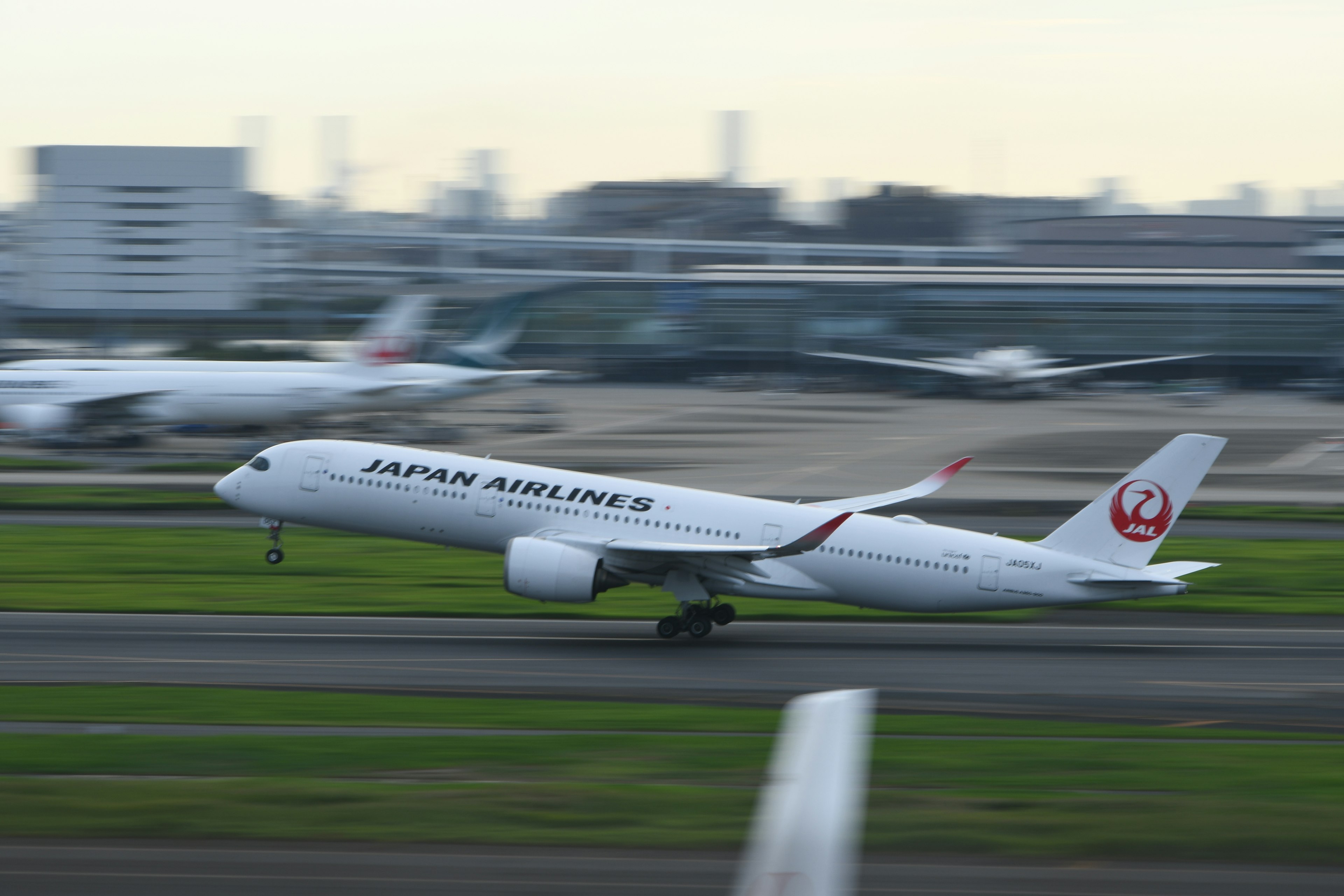 日本航空の航空機が滑走路を離陸するシーン