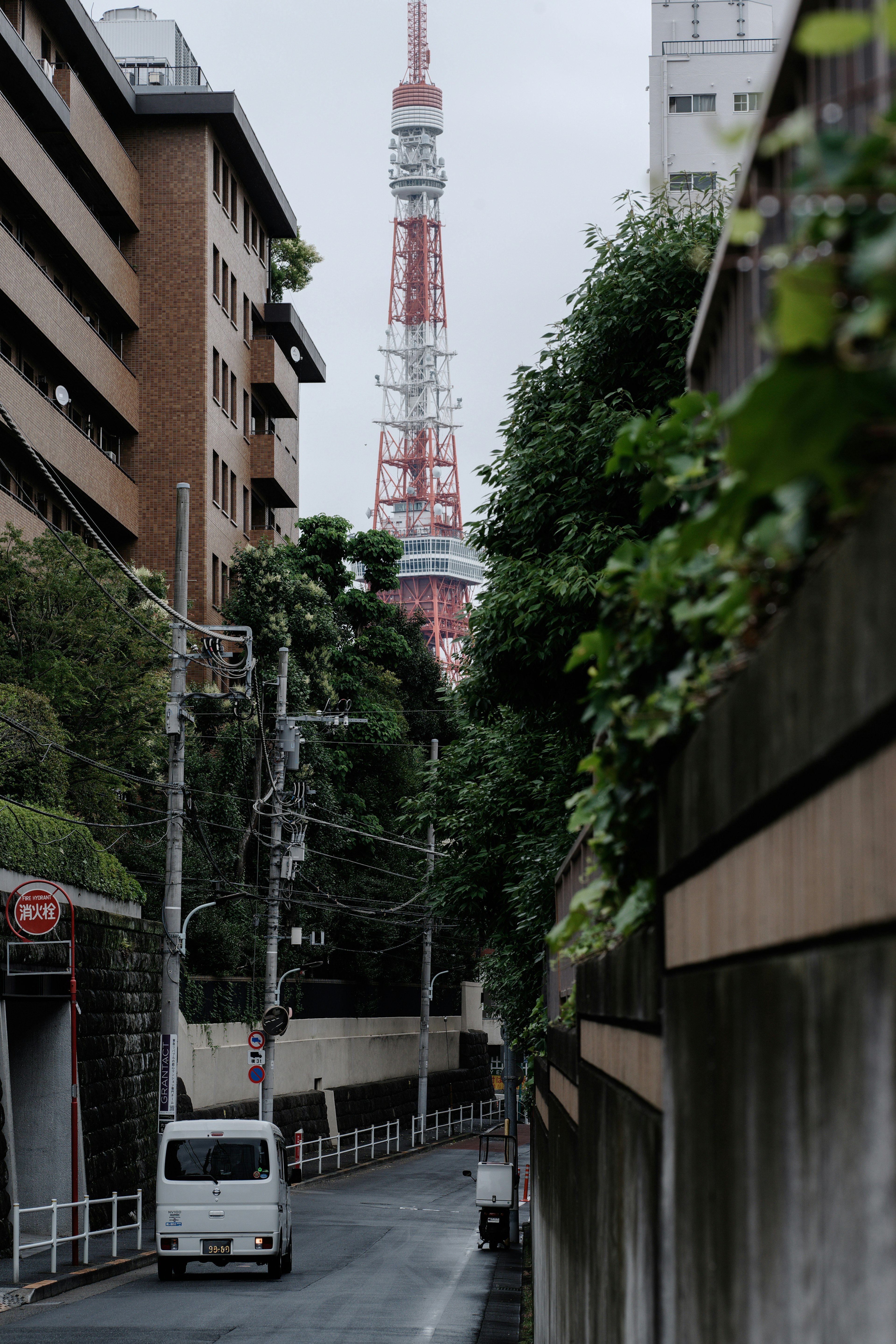 Gang sempit dengan Menara Tokyo terlihat di latar belakang