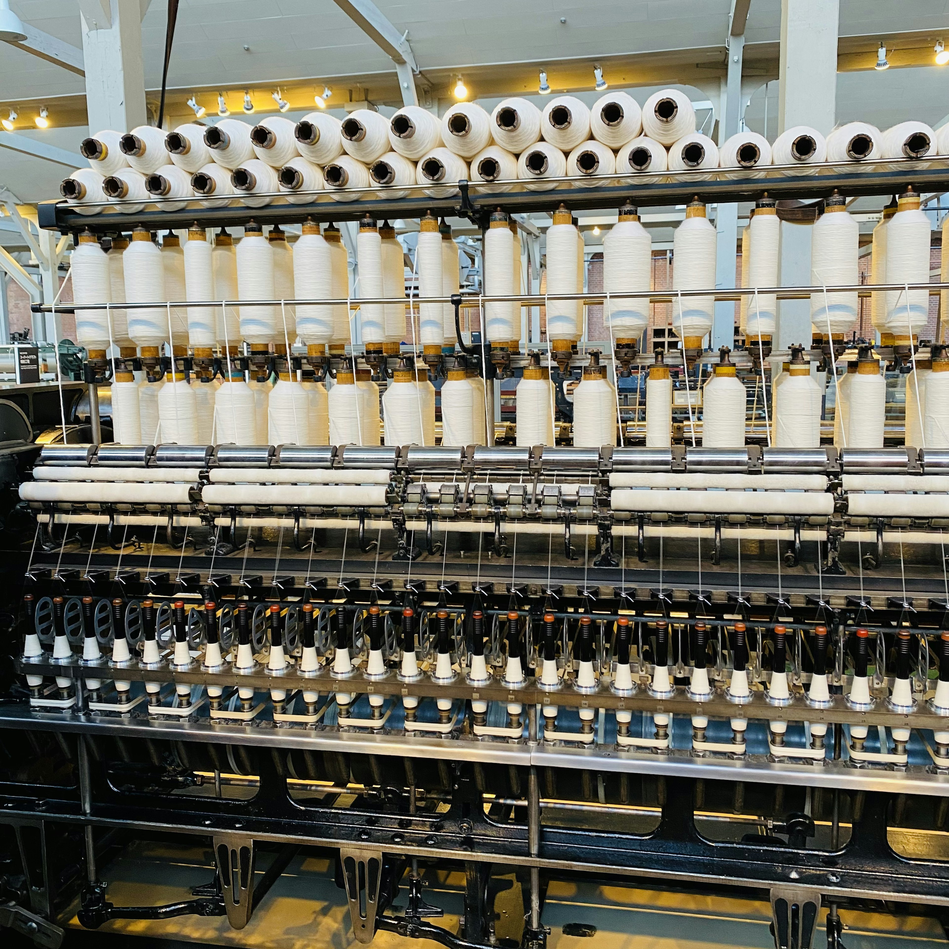 Intérieur d'une usine textile avec des bobines et du fil sur une machine à tisser