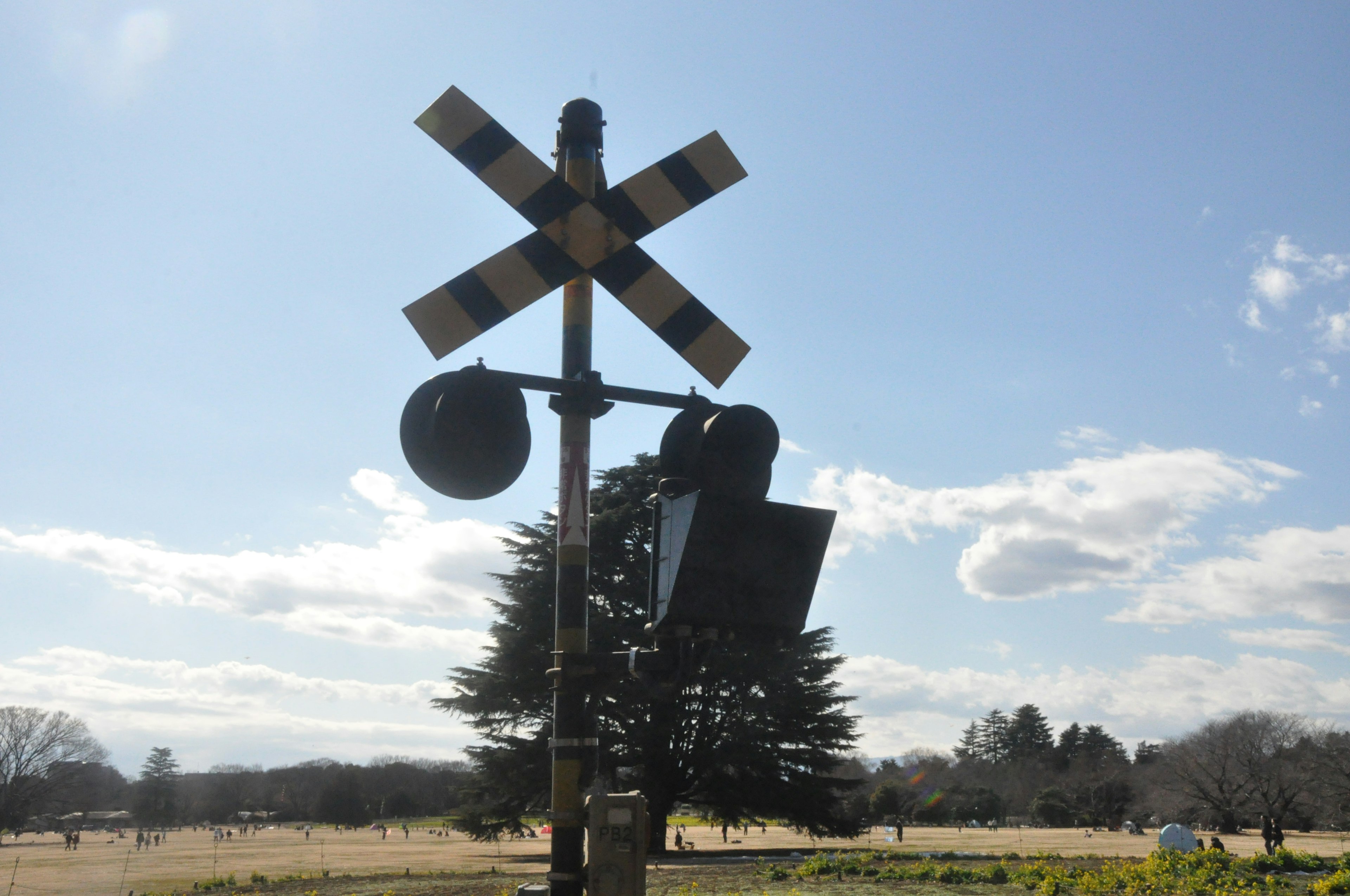 Railroad signal and warning sign under a clear blue sky