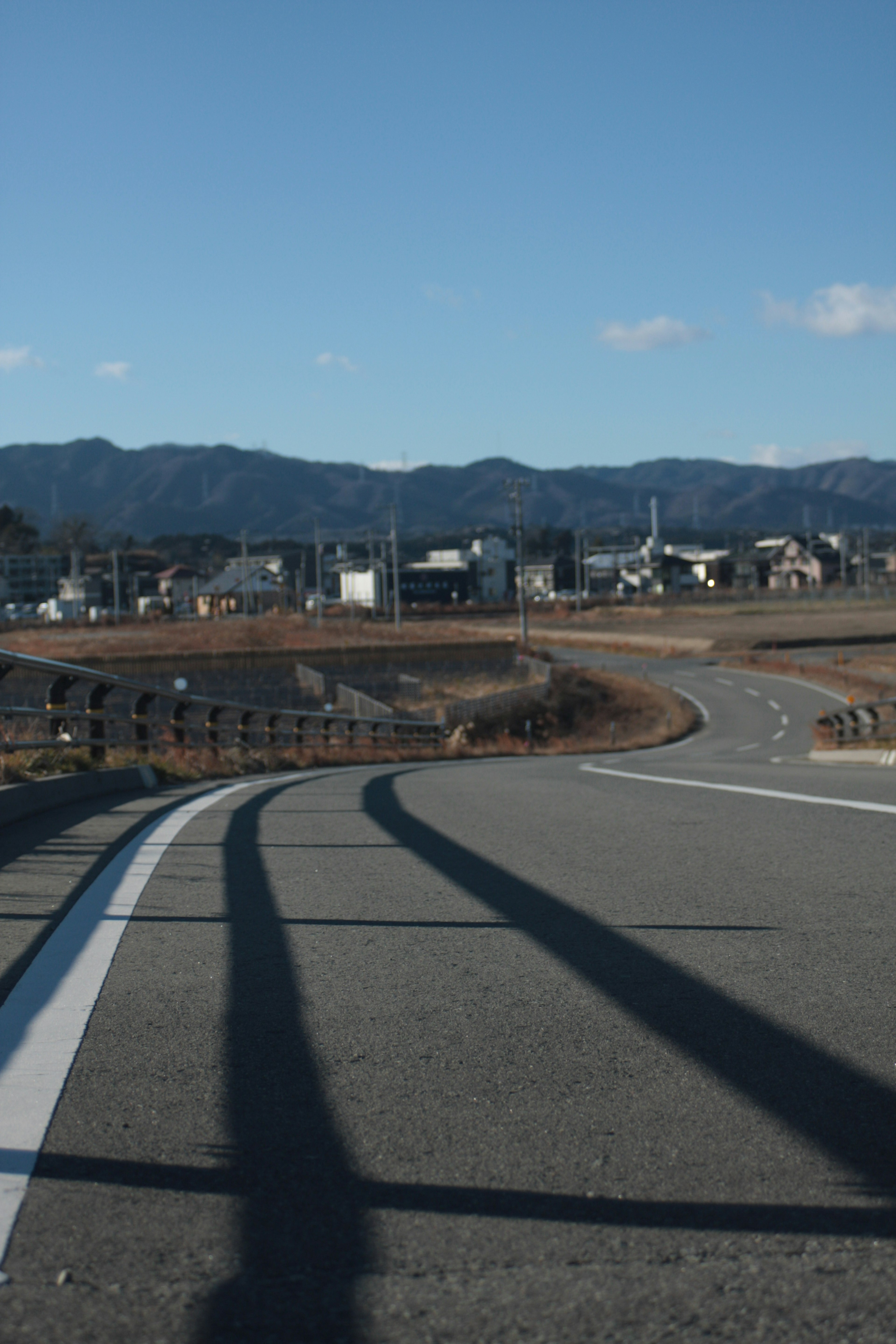 Curved road with blue sky and distant mountains