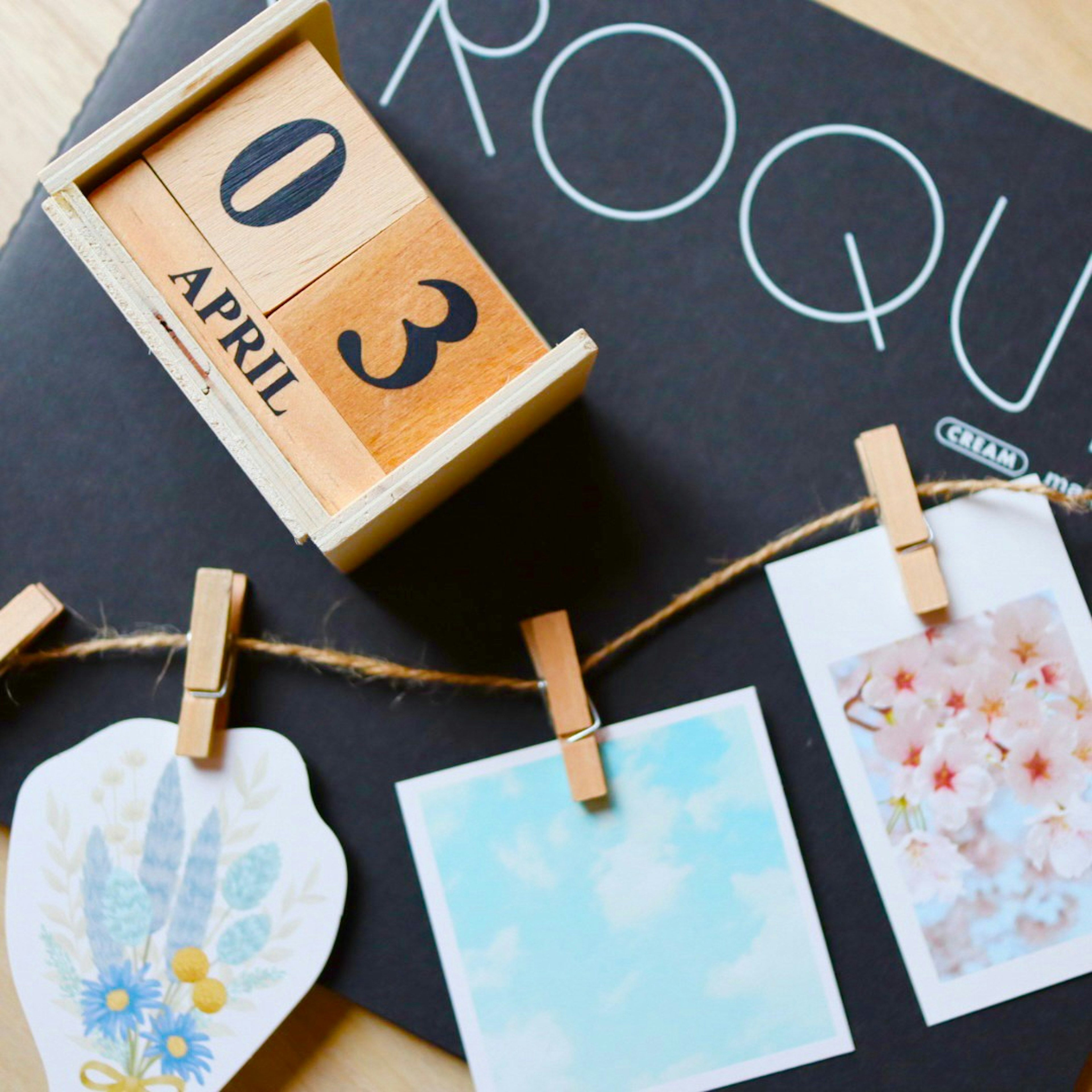 Wooden calendar with the date April 3 and floral postcards hanging