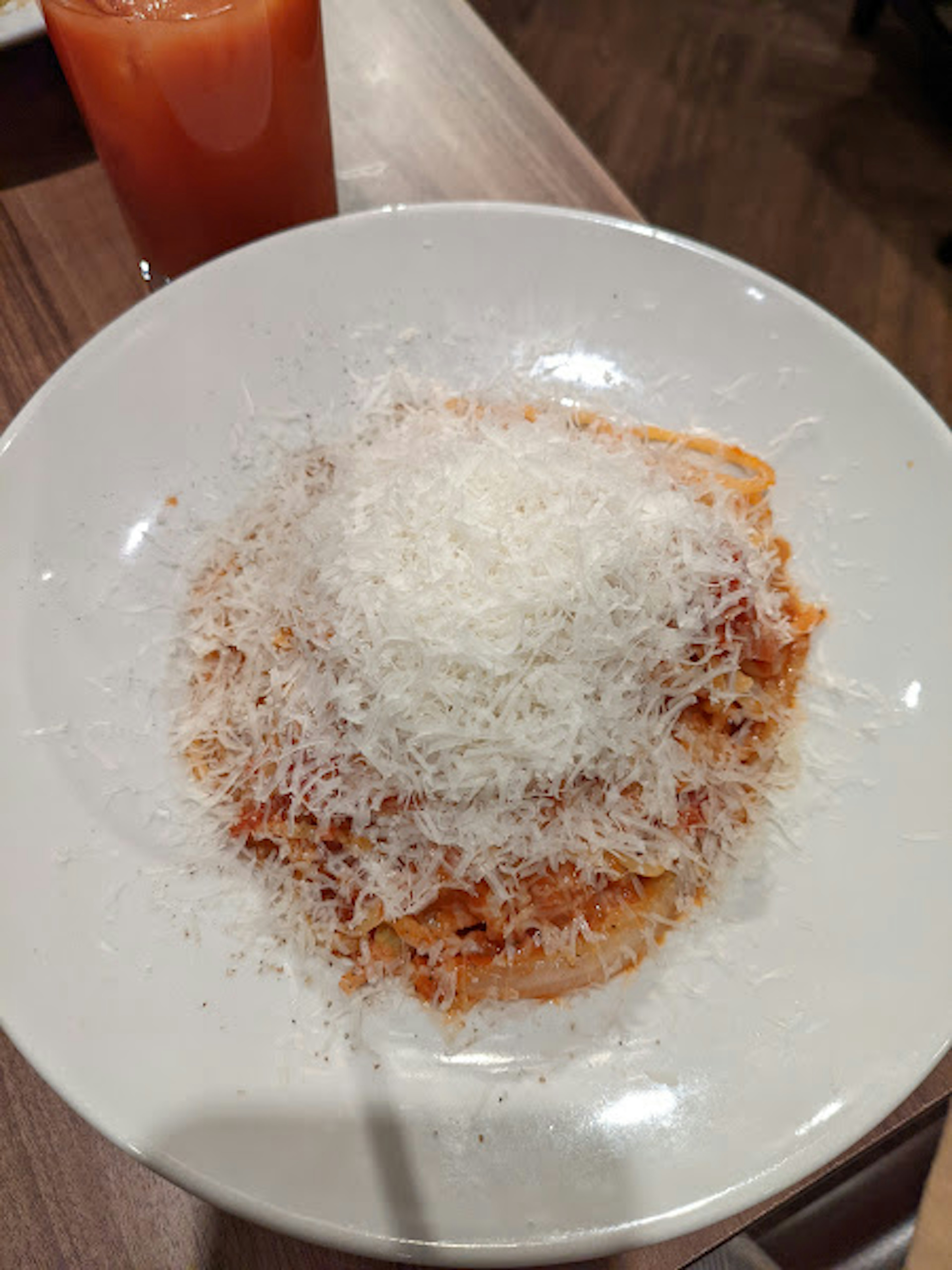 Ein Teller Pasta mit geriebenem Käse und roter Sauce