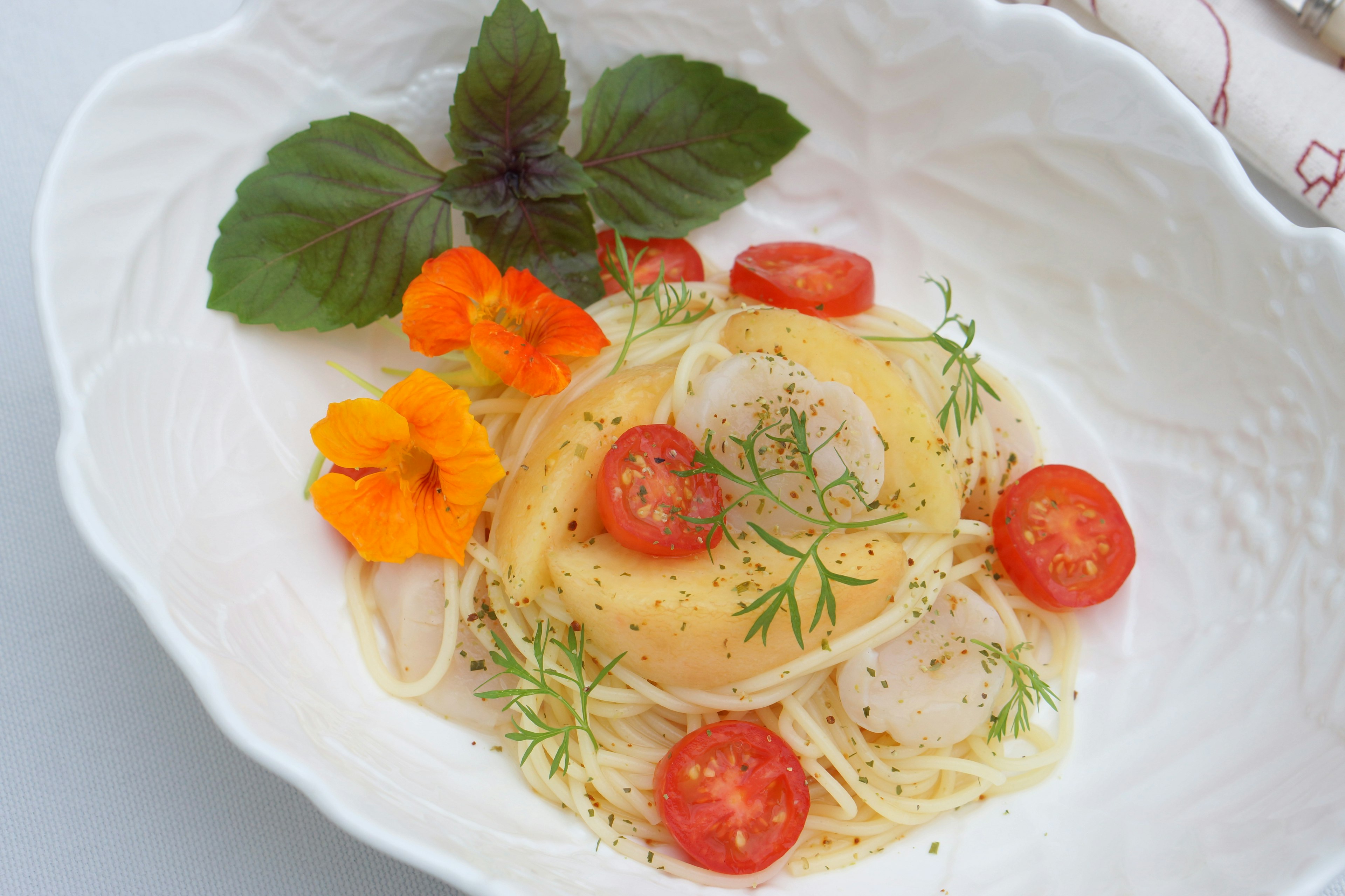 Un hermoso plato de pasta adornado con tomates y hierbas