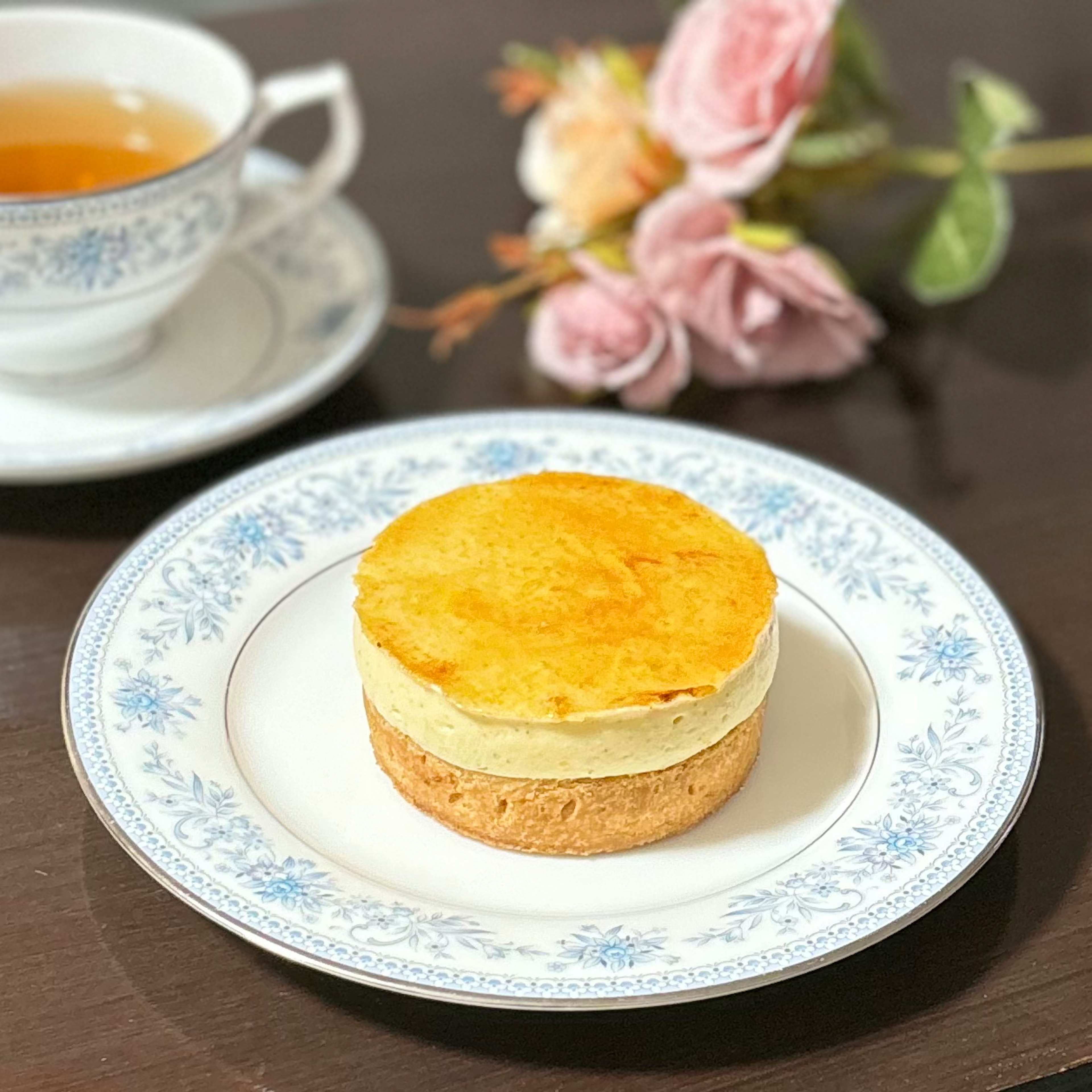 美しいお皿に置かれたケーキと紅茶のセット 花が添えられた