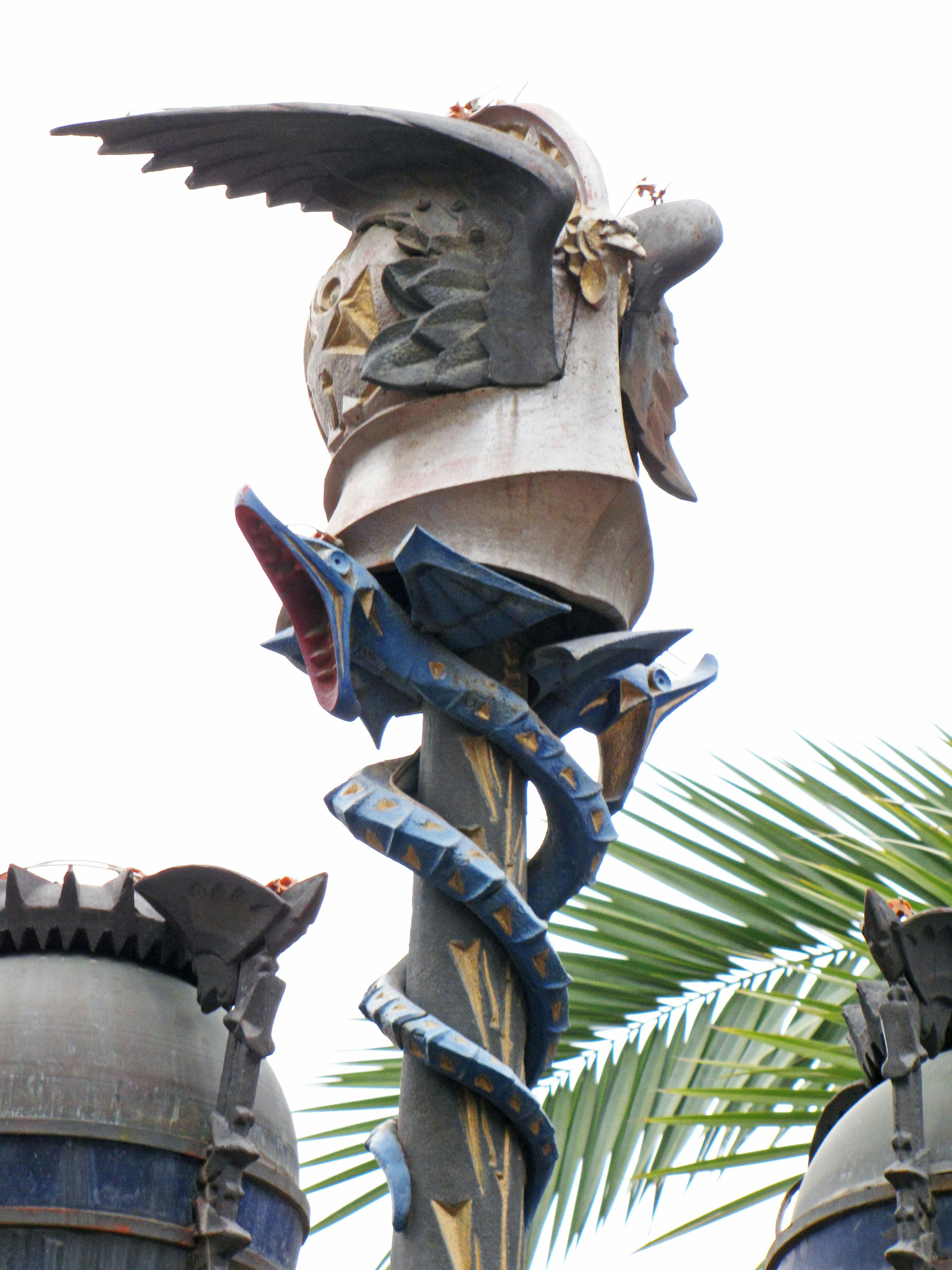 Decorative helmet with eagle and serpent sculpture atop a pole