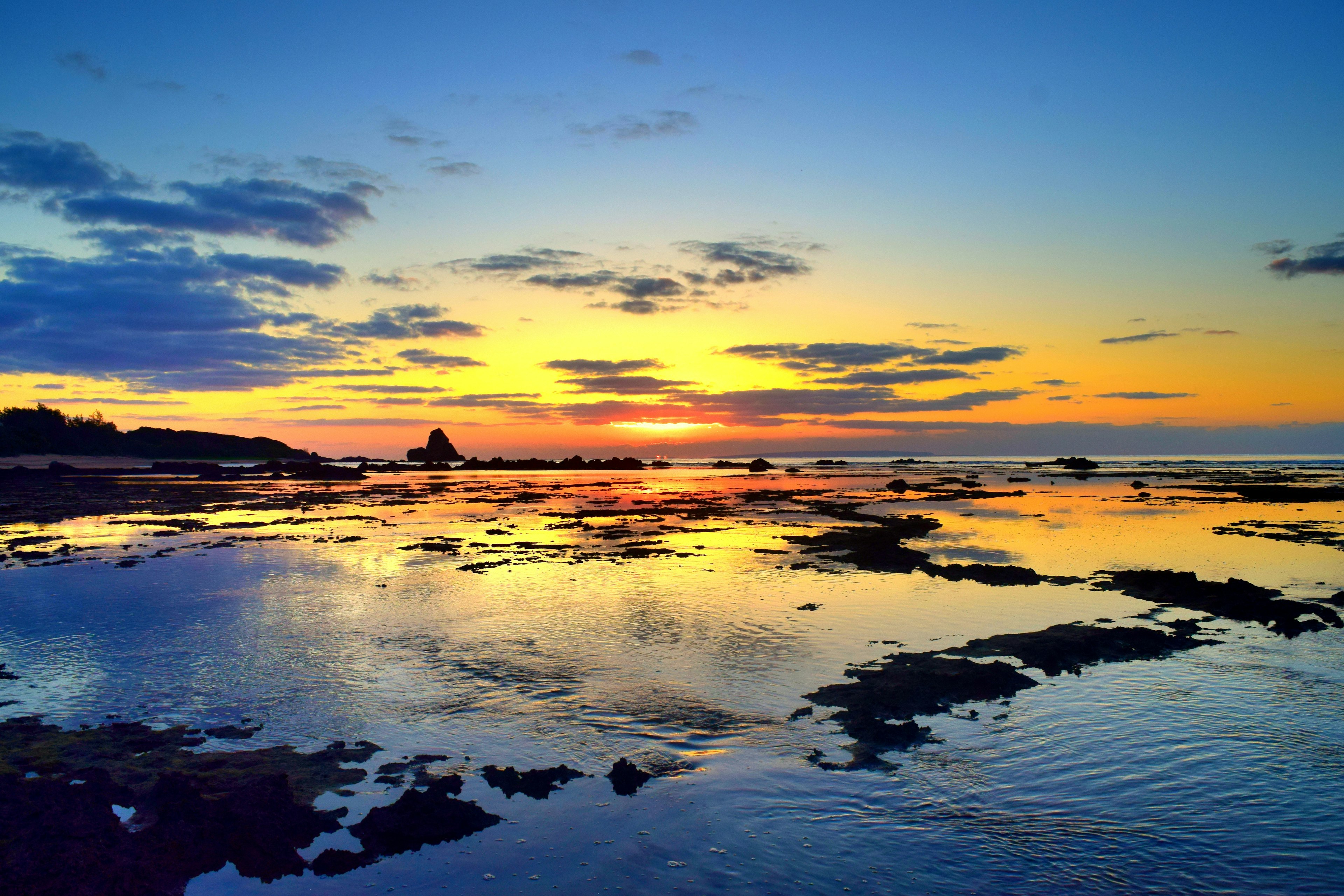 Beautiful sunset over the ocean with colorful reflections on the calm water