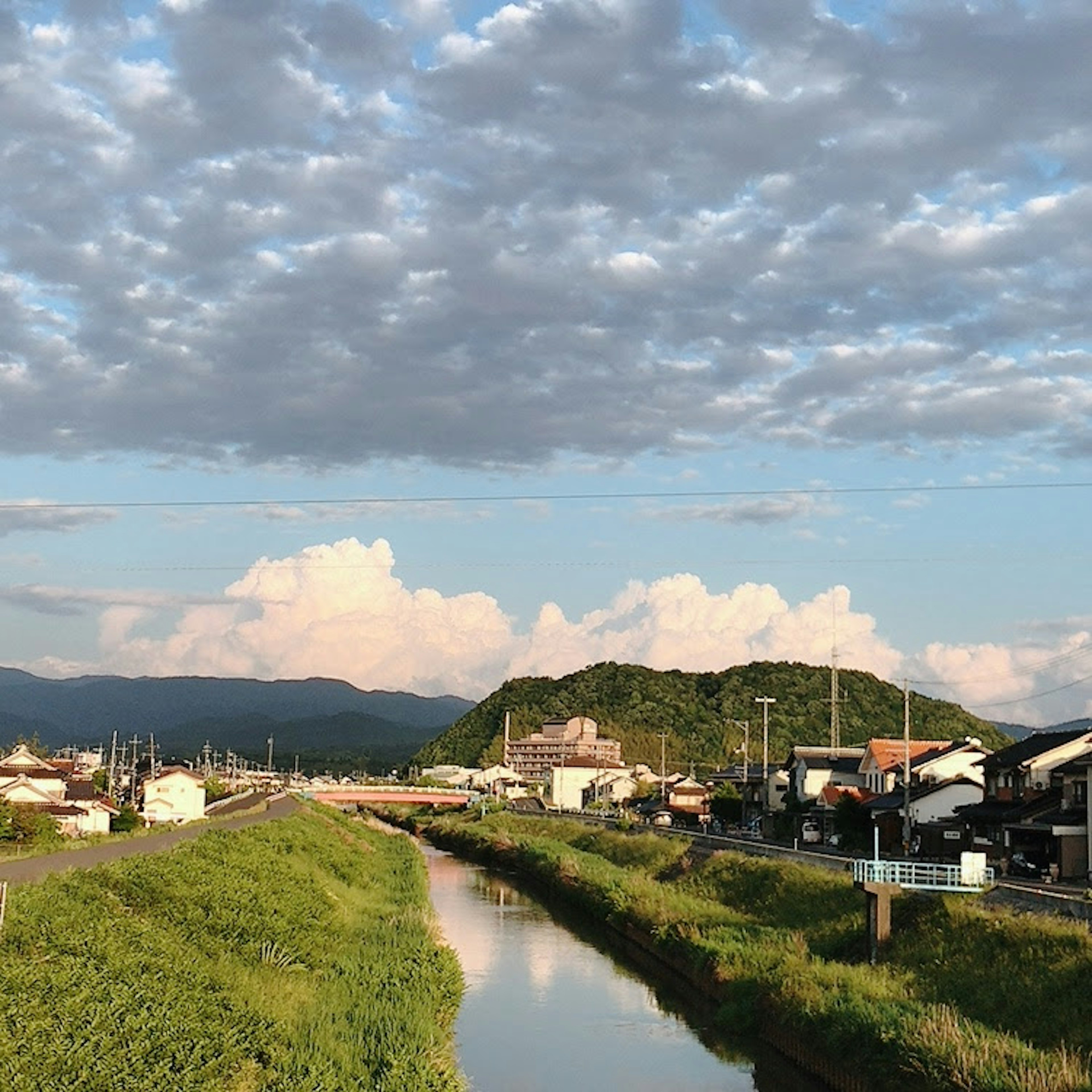 ทิวทัศน์ของแม่น้ำพร้อมเมฆ บ้านในหมู่บ้านและภูเขา