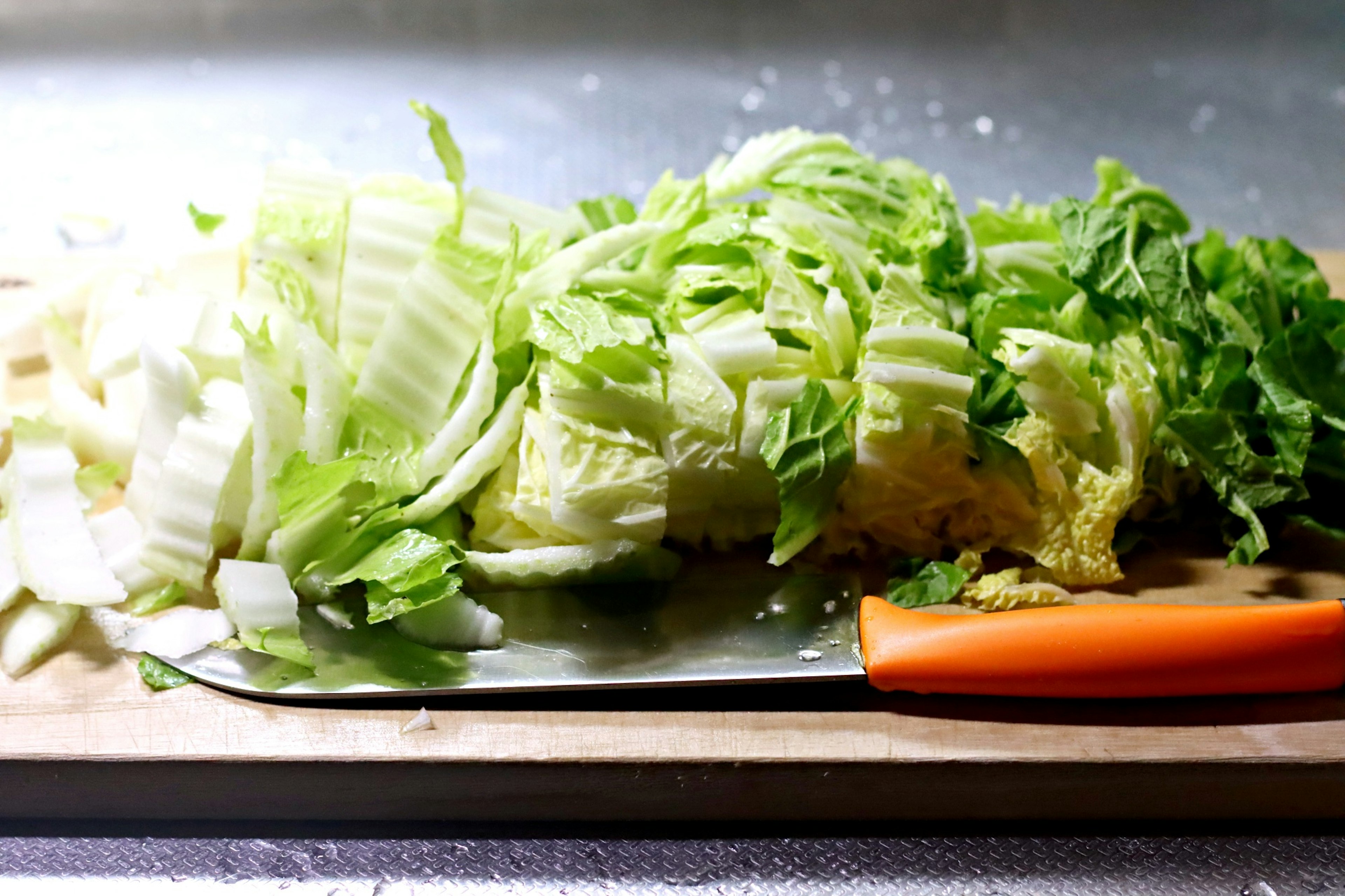 切った野菜が並ぶまな板と包丁の写真