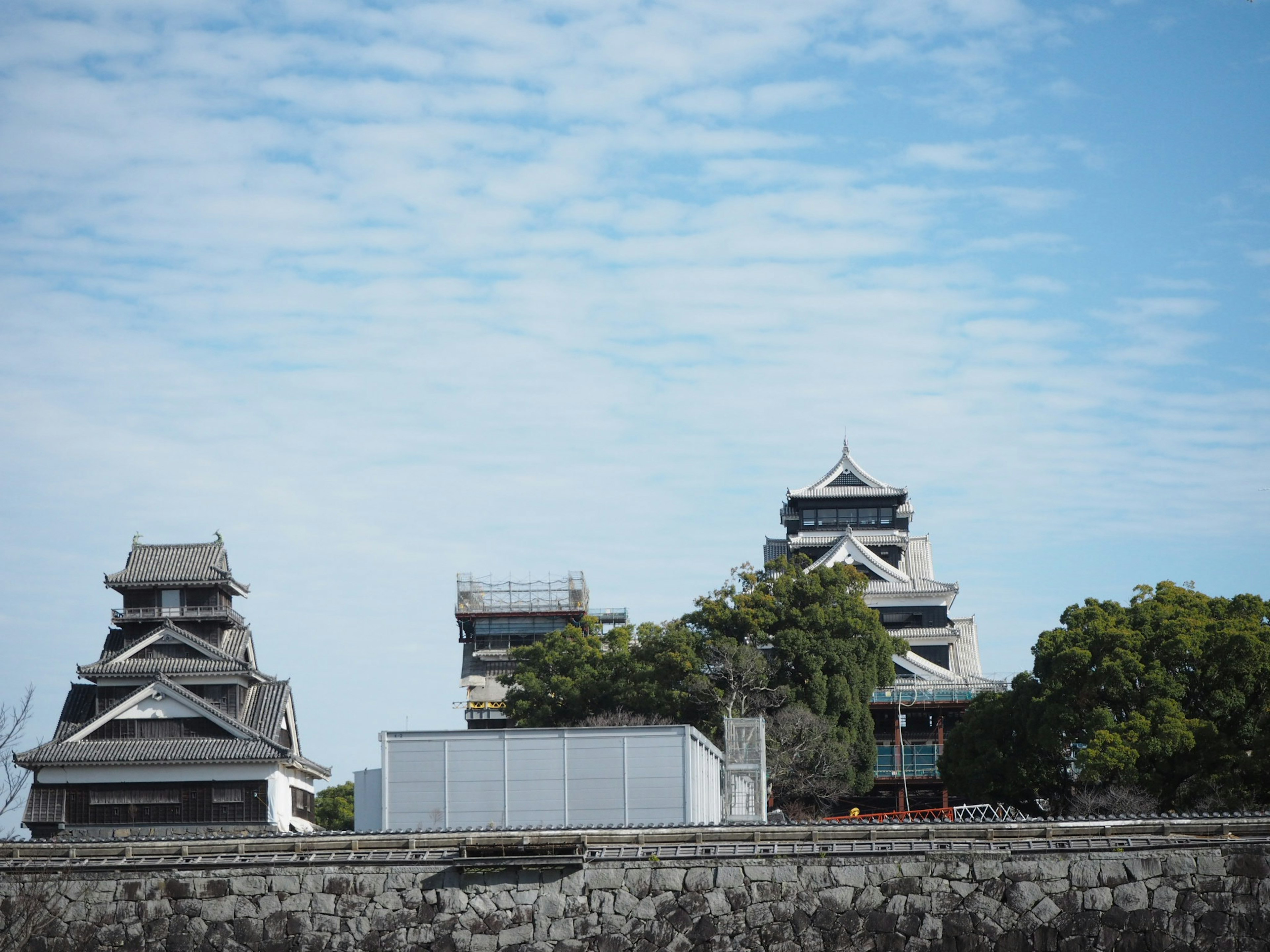 Château japonais traditionnel avec des toits noirs sous un ciel bleu