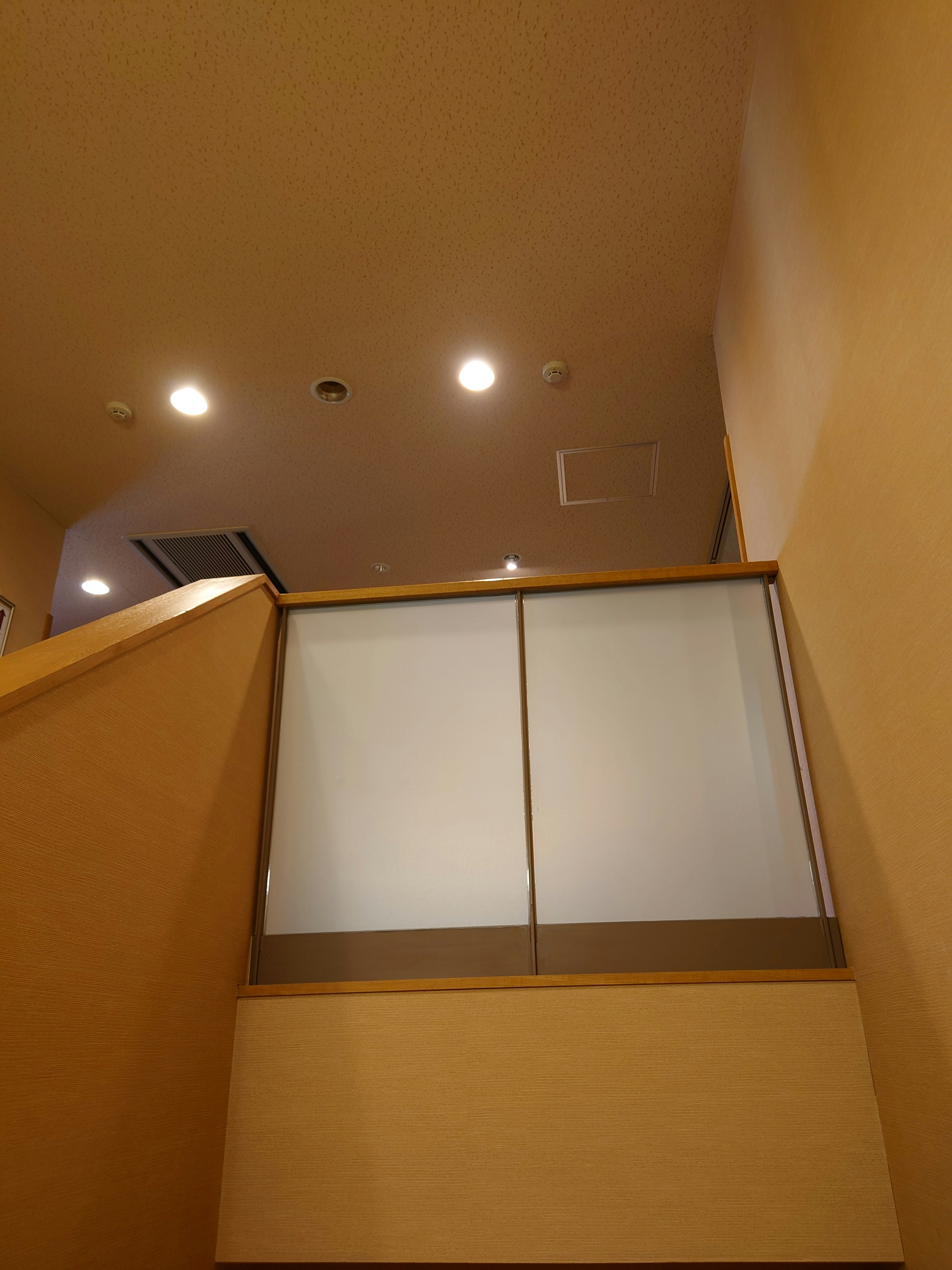 Indoor view looking up at a staircase with warm lighting