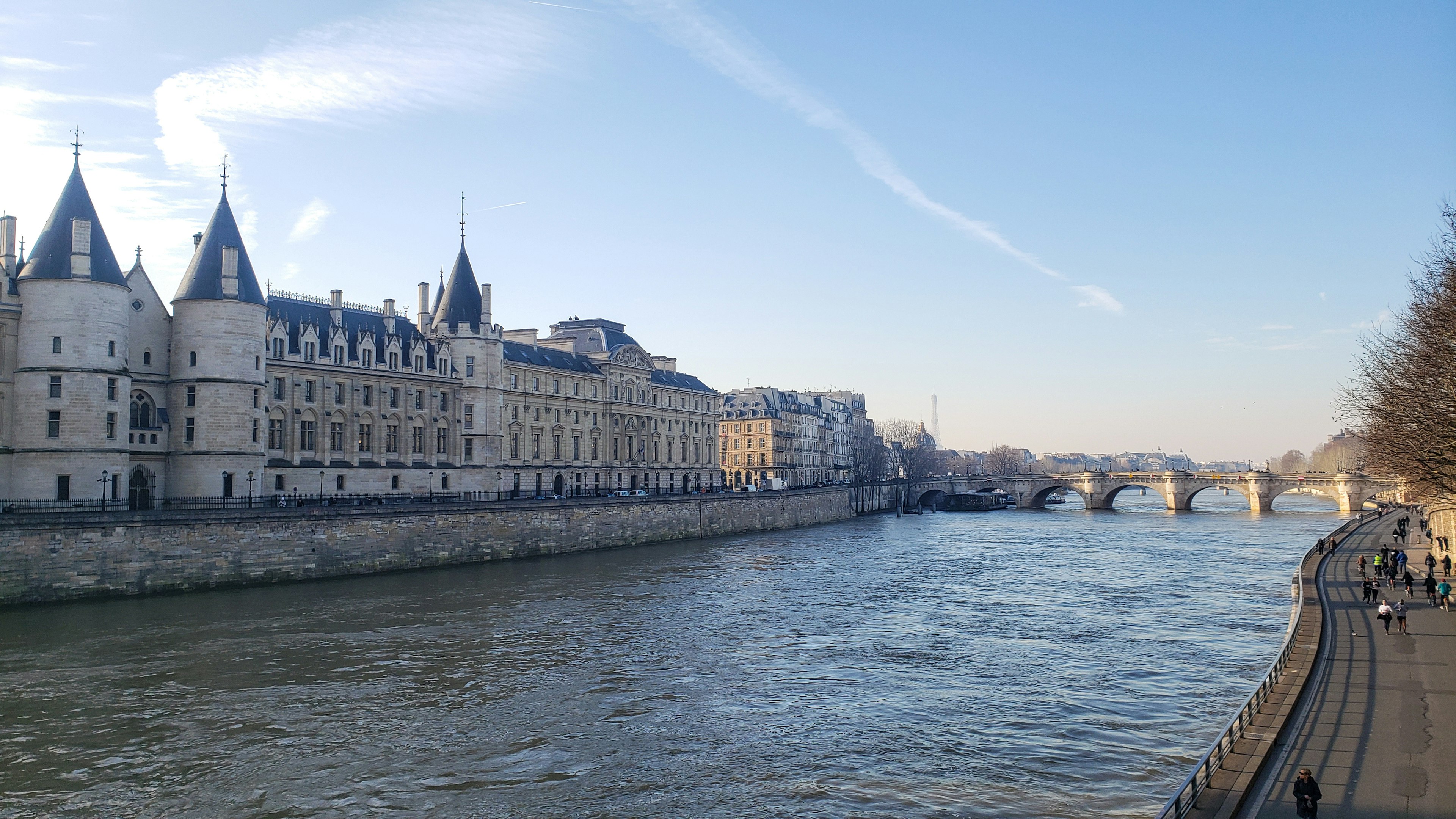 Historic buildings along the Seine River with a clear blue sky