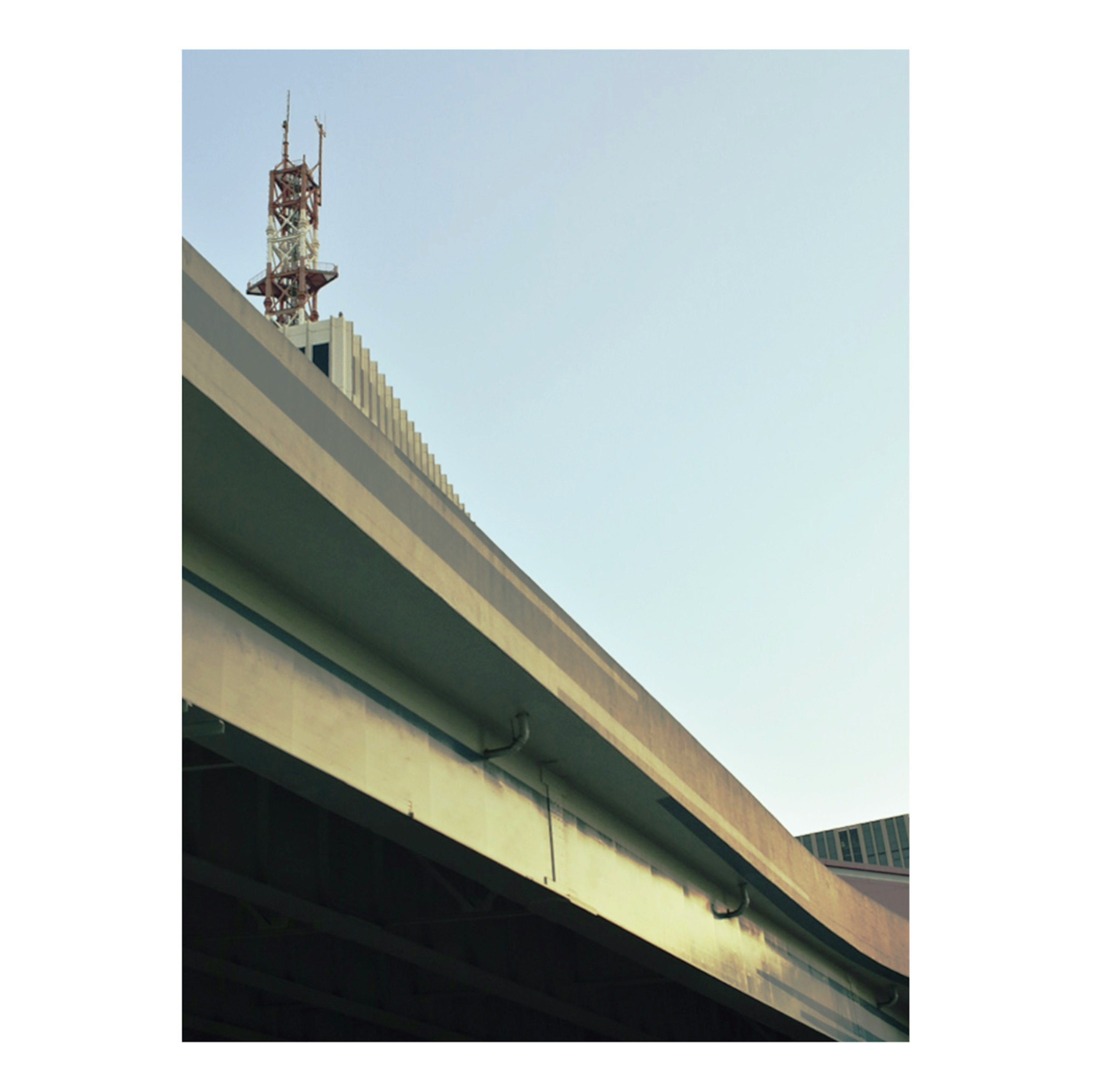 Composizione di un'autostrada sopraelevata e di una torre di comunicazione su sfondo di cielo blu