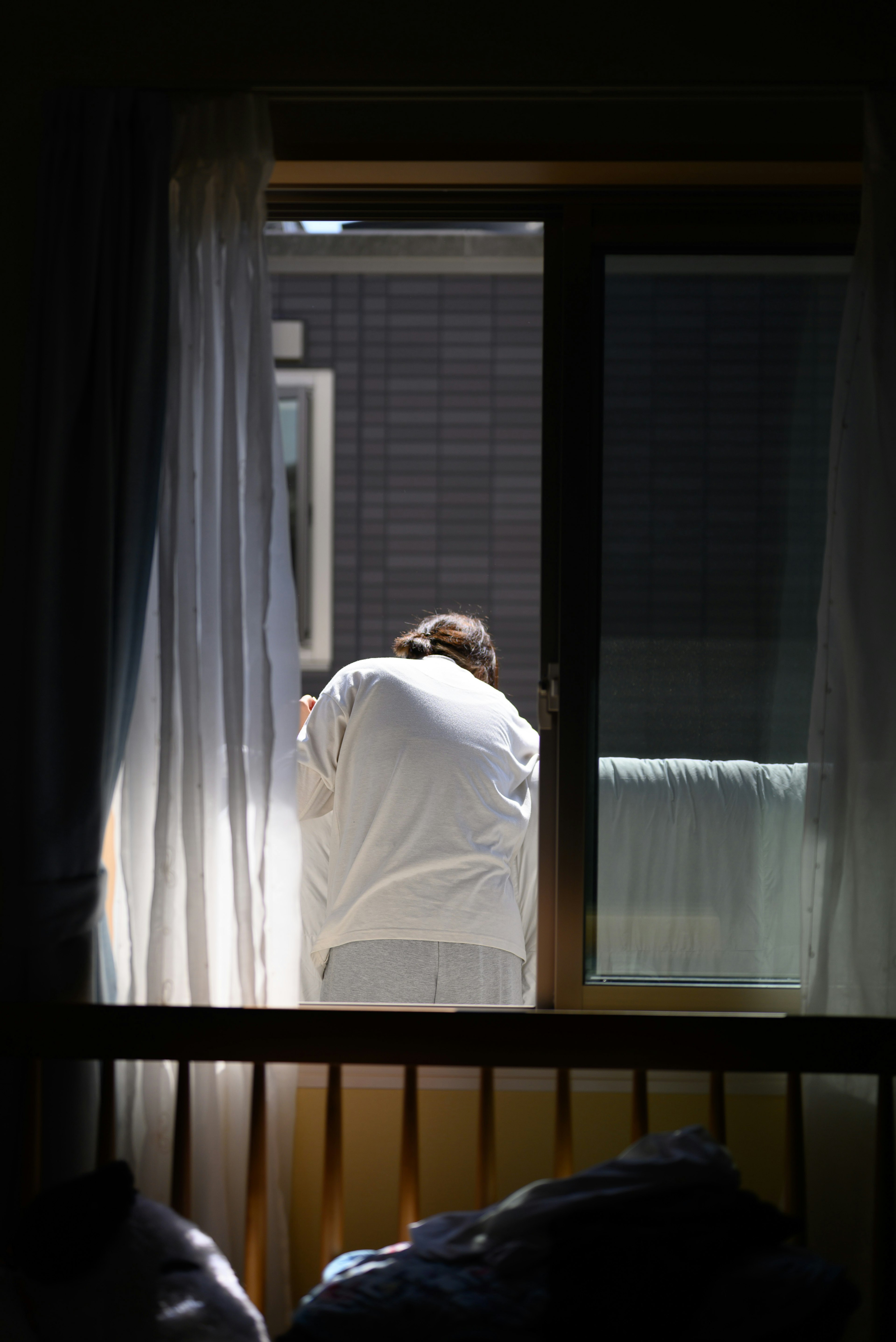 Person schaut aus dem Fenster Sanftes Licht beleuchtet den Raum