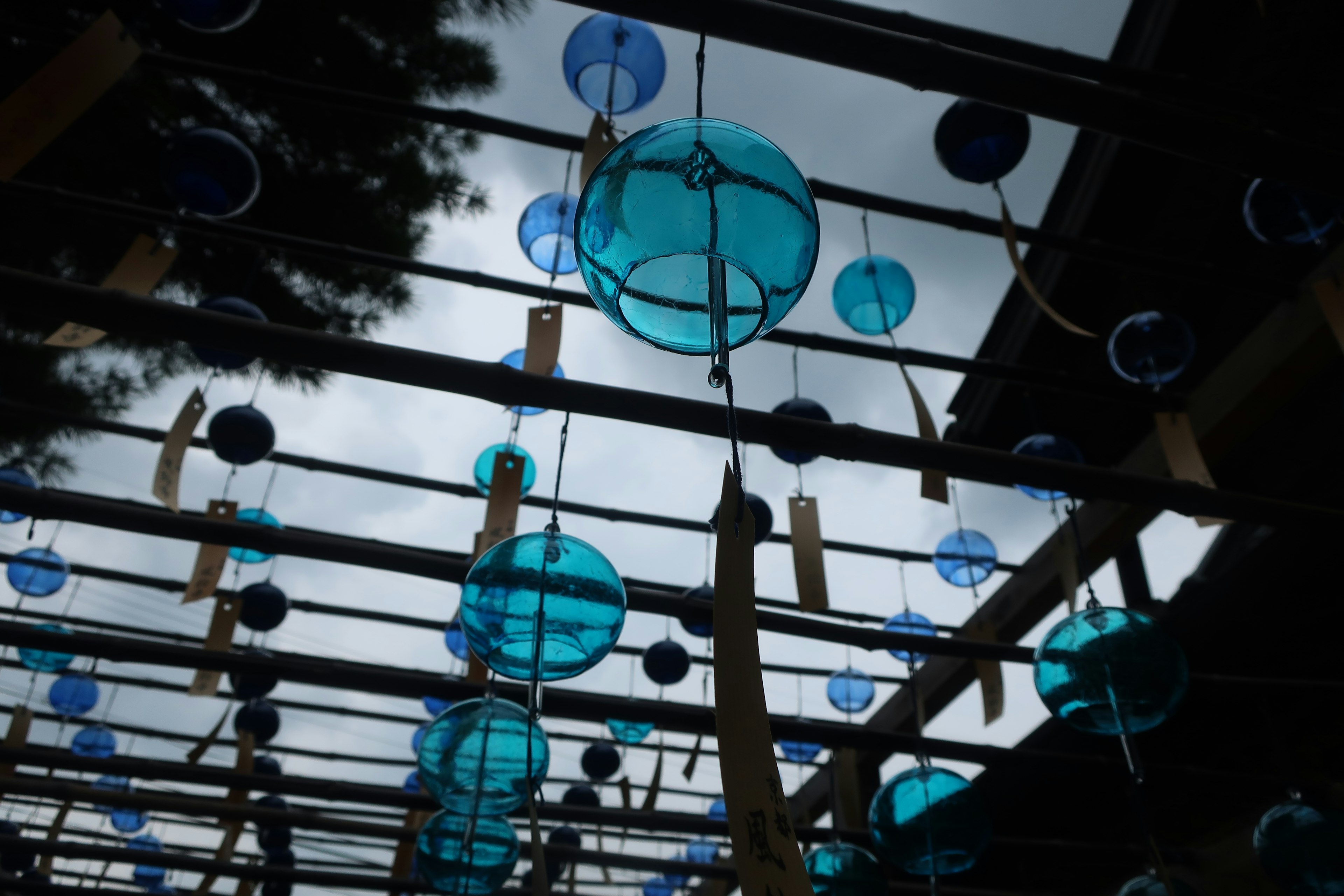 View from below of wooden structure with hanging blue spherical lanterns