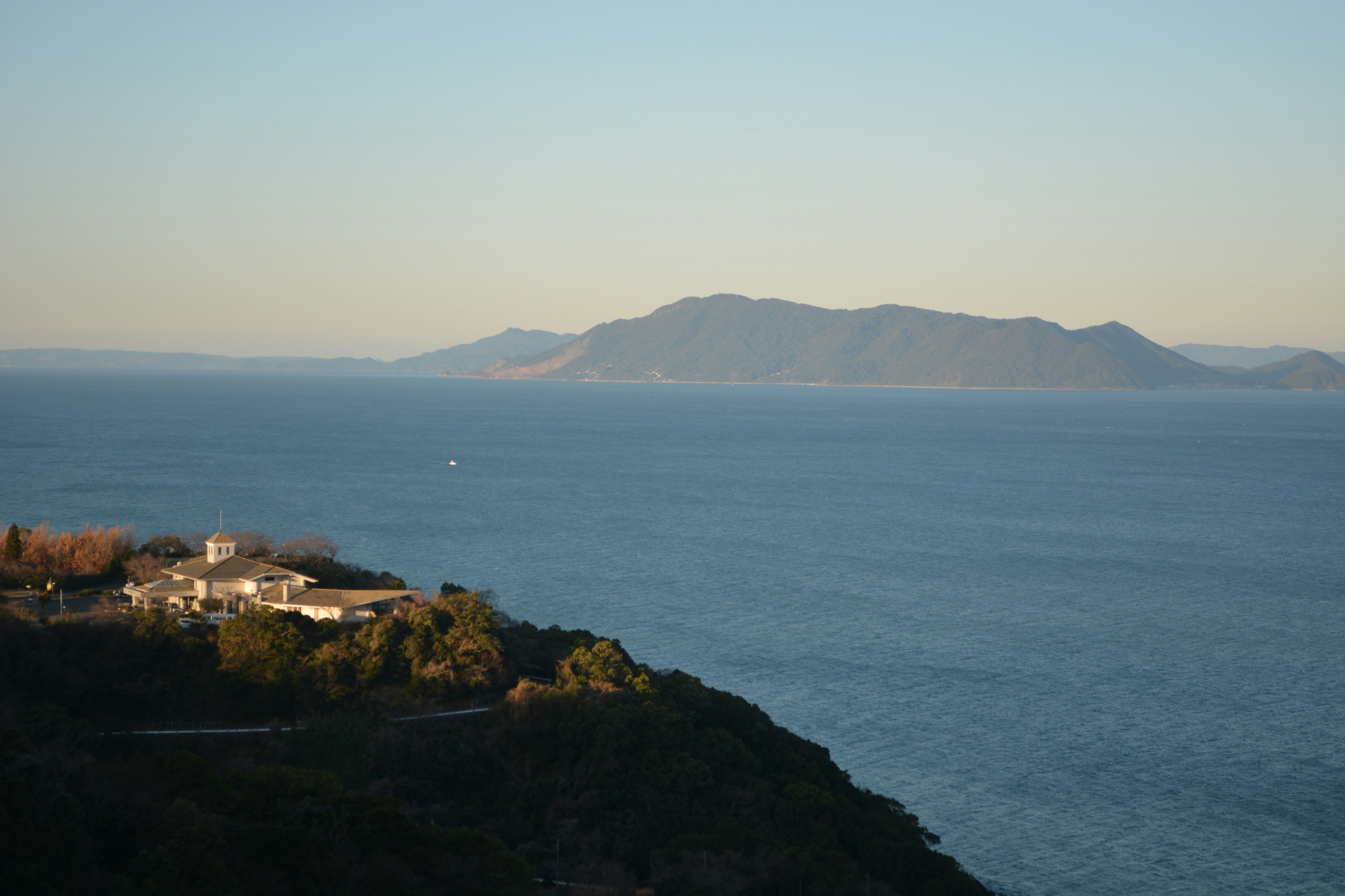 Vista escénica del océano con montañas distantes y una isla