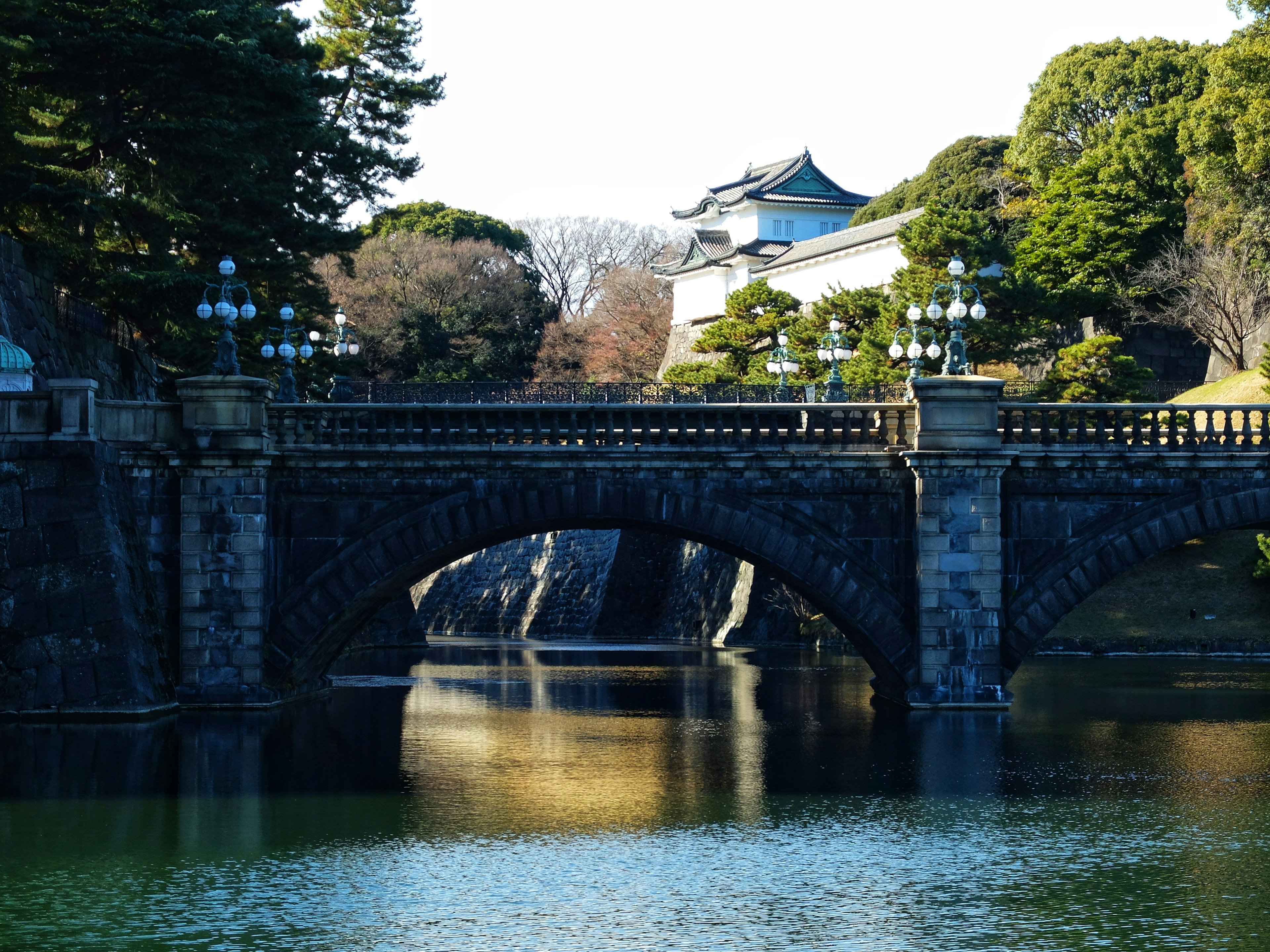 Vista escénica del puente Nijubashi en el Palacio Imperial reflejándose en aguas tranquilas