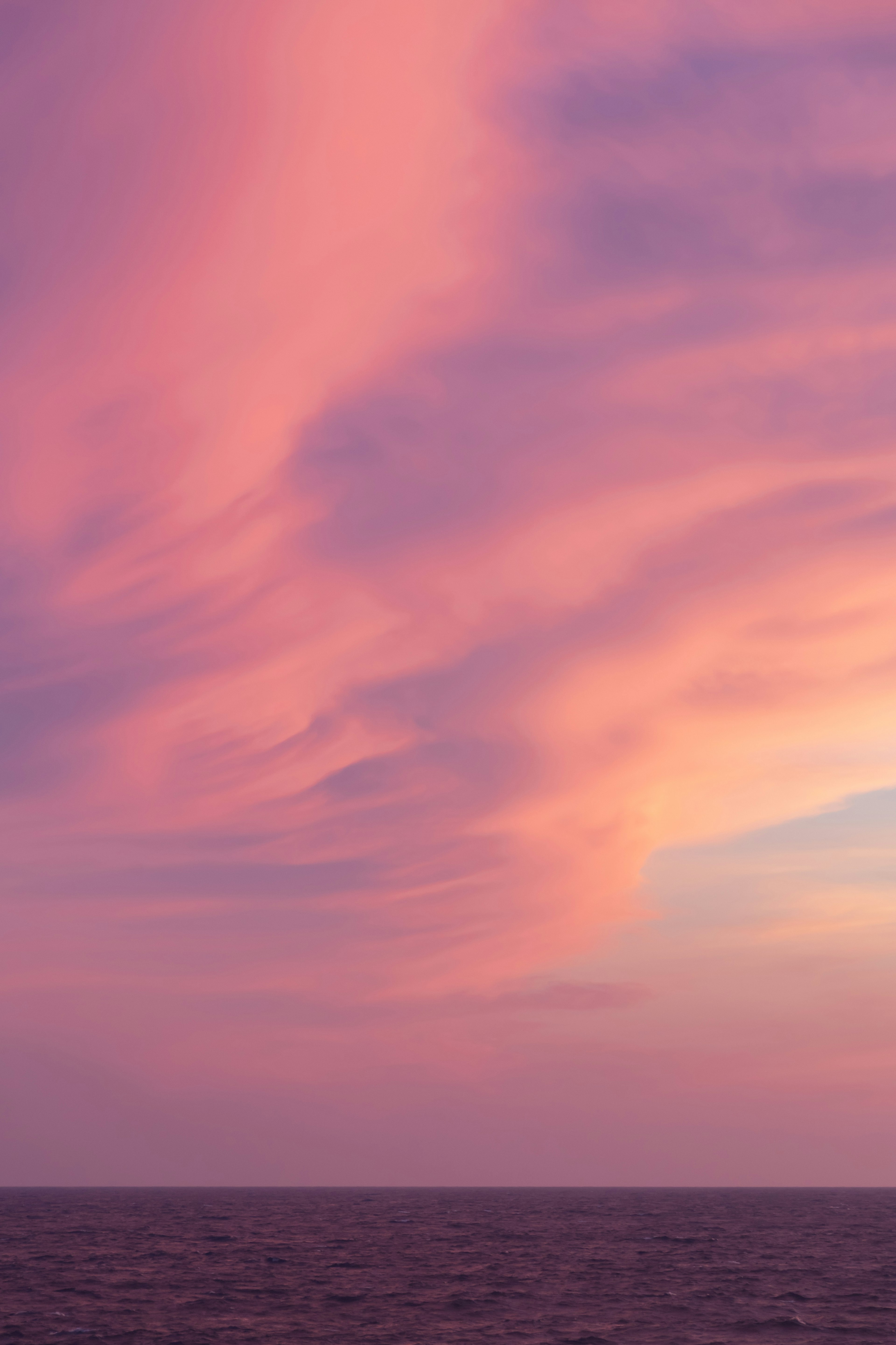 Hermoso cielo al atardecer con nubes rosas y moradas sobre el océano