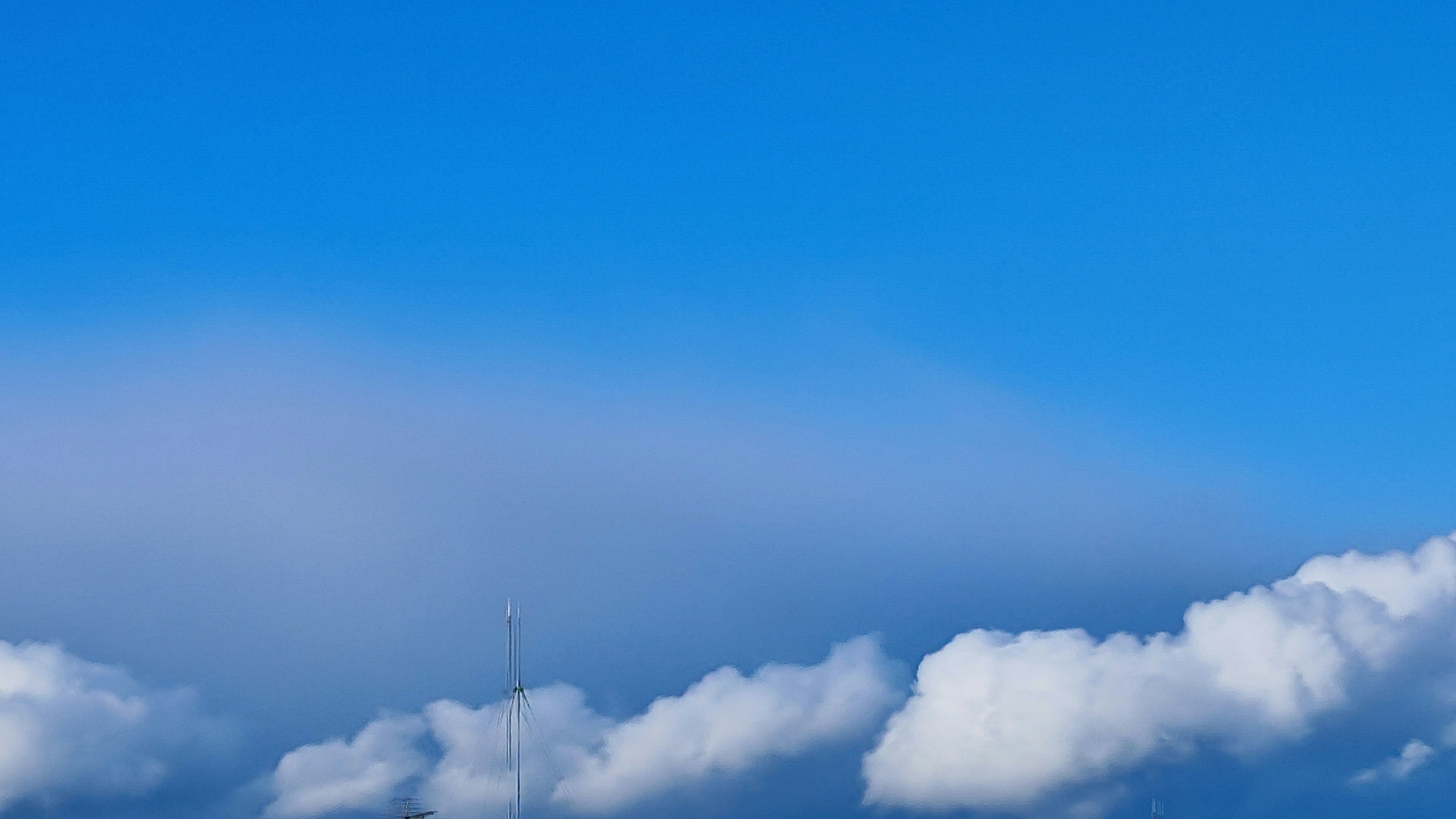 Klarer blauer Himmel mit flauschigen weißen Wolken