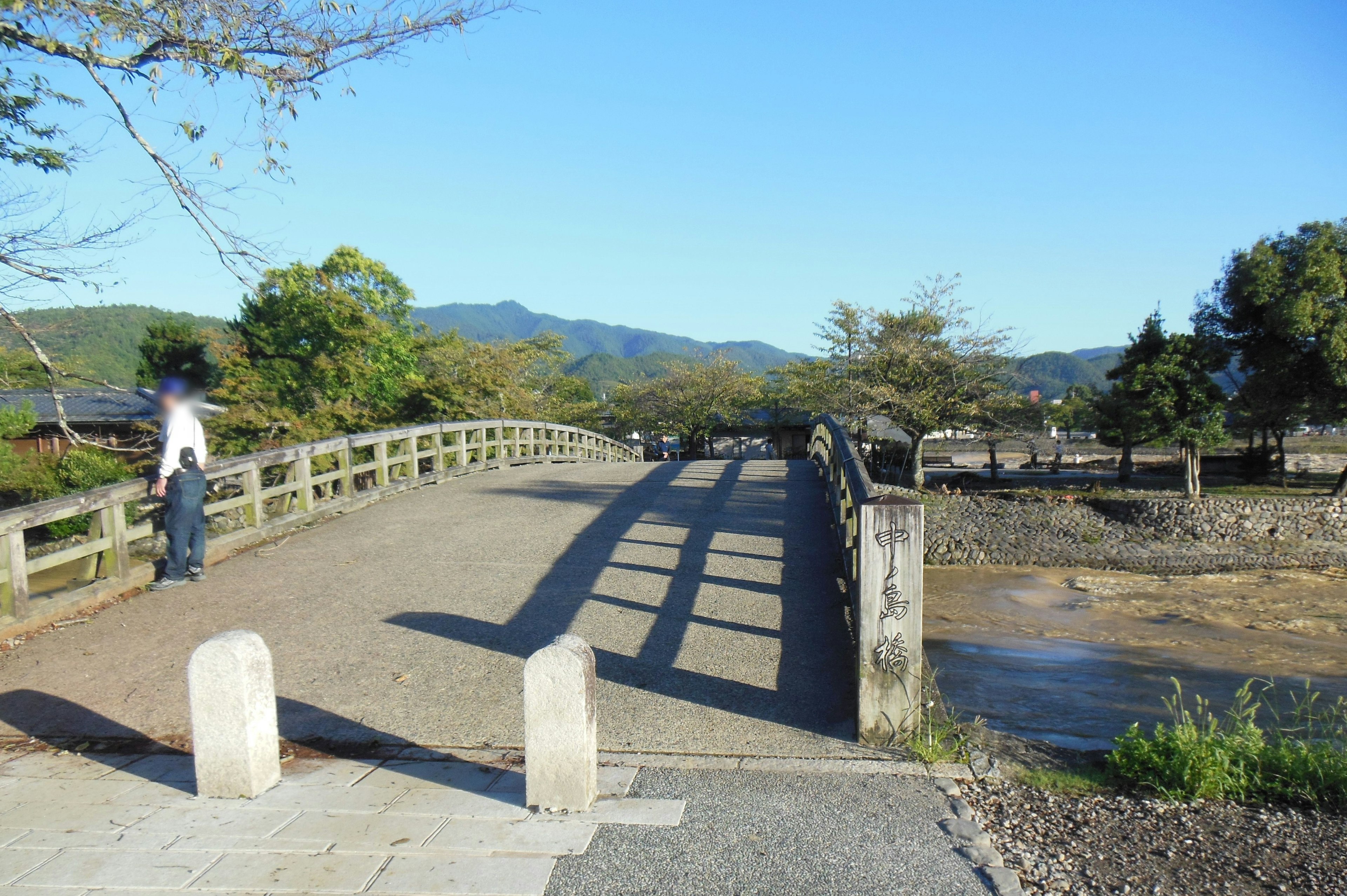 Una vista pacífica de un puente sobre un río con montañas distantes al fondo