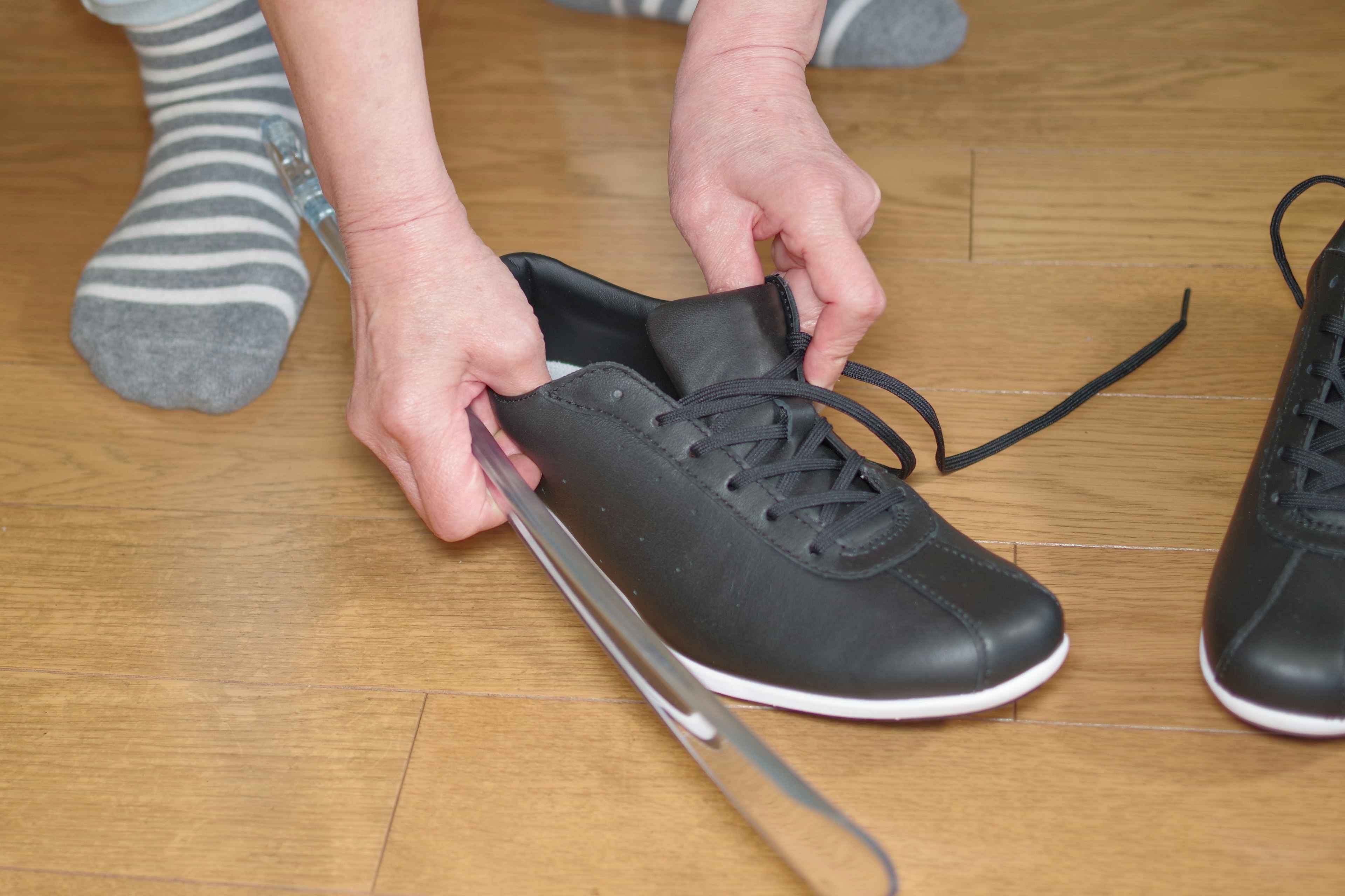 Manos preparándose para atar zapatillas negras