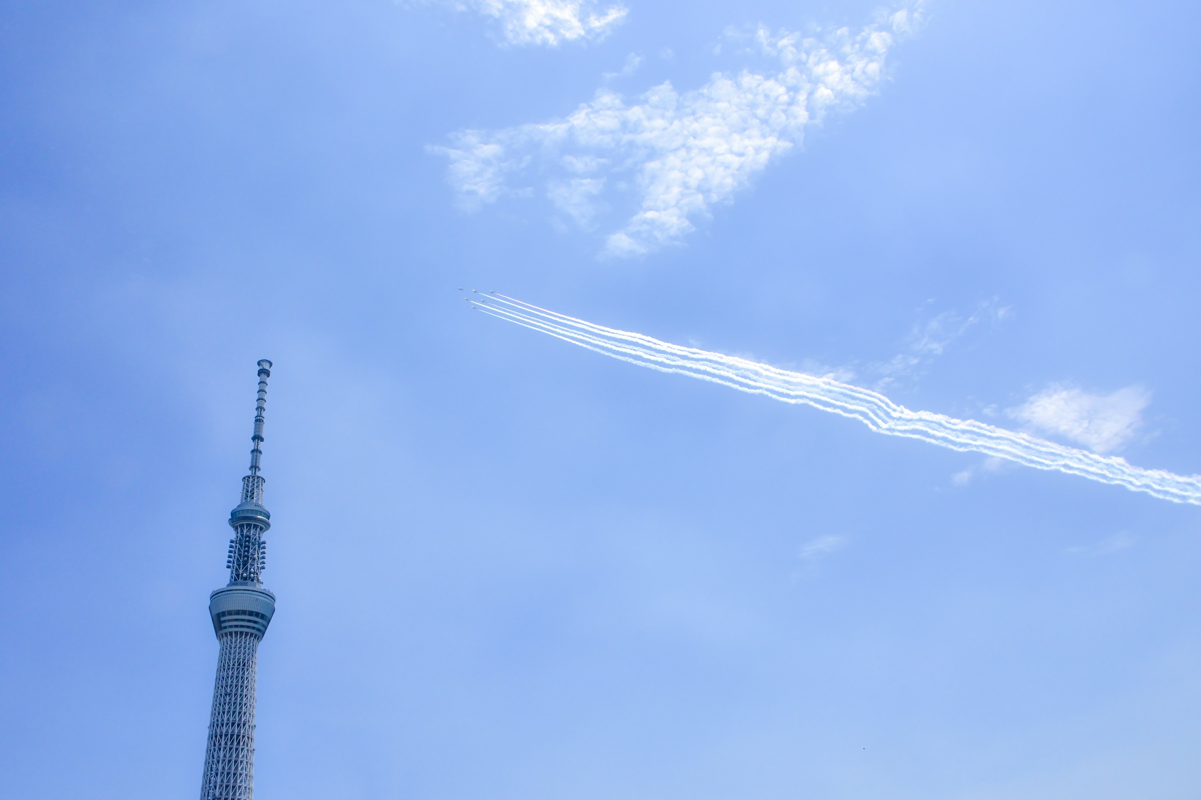 Tokyo Skytree contro un cielo blu chiaro con scie di condensa