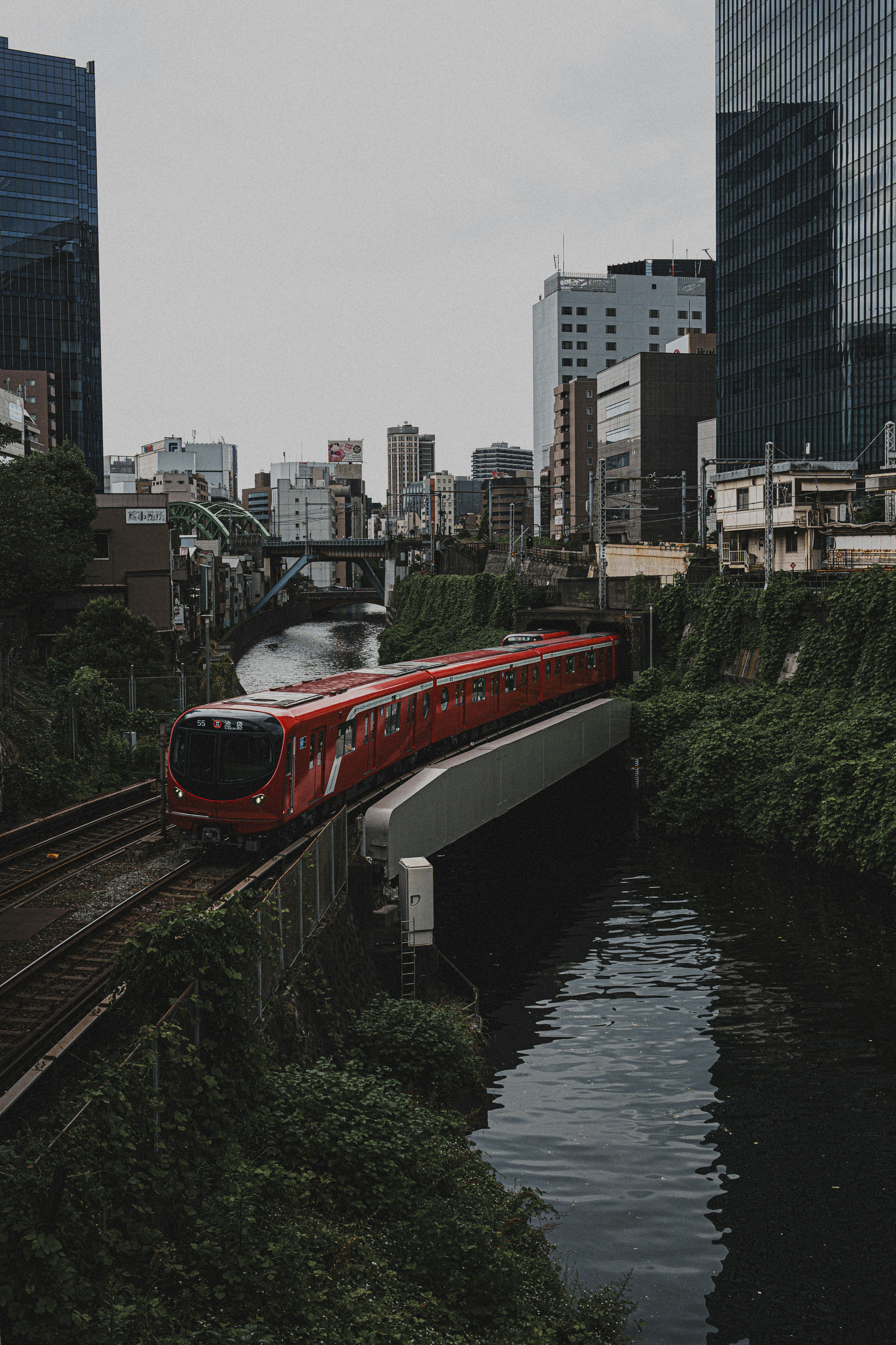 红色火车在建筑物之间行驶