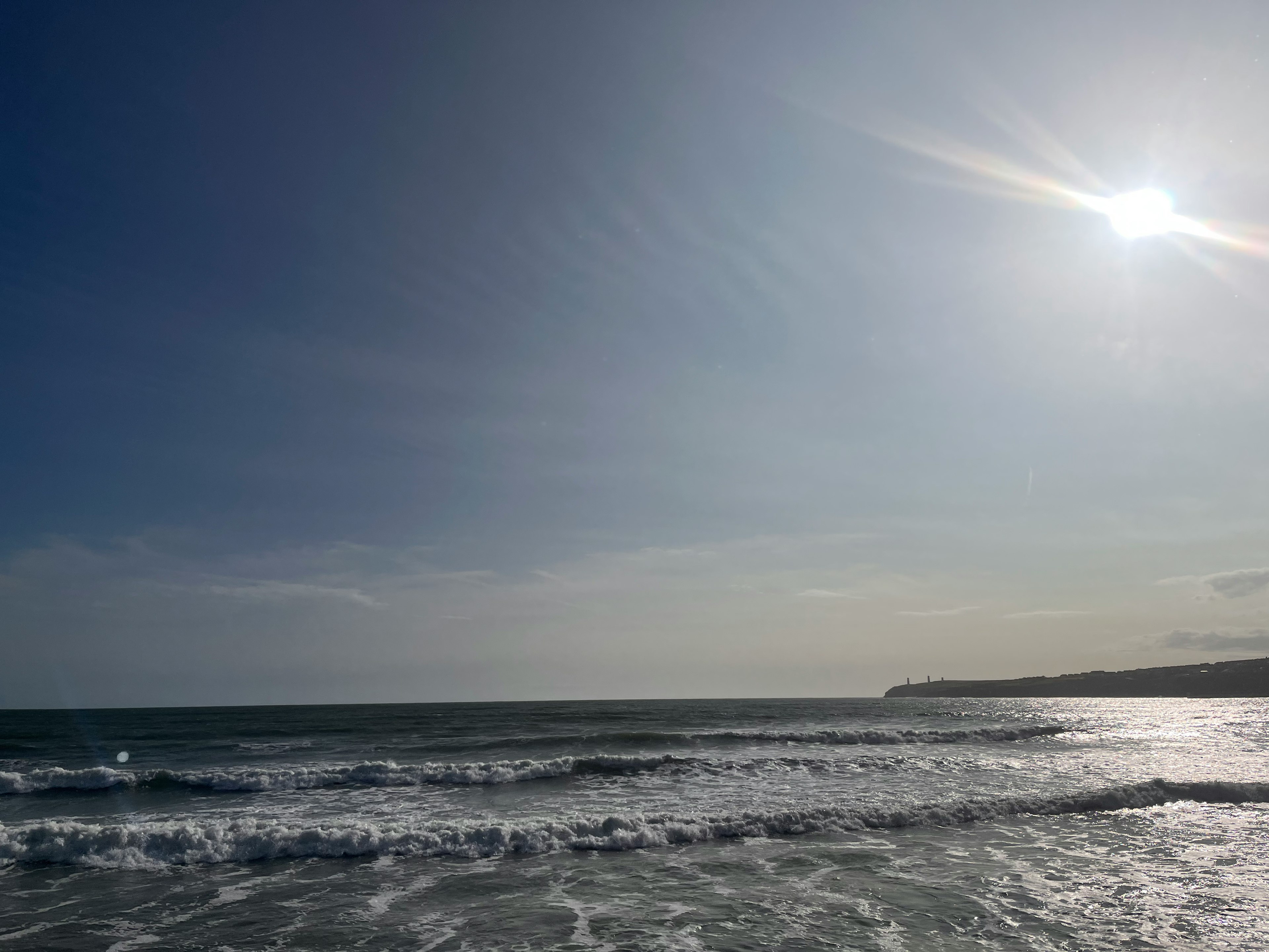 Calm sea and blue sky scenery Sun shining over the wavy coastline