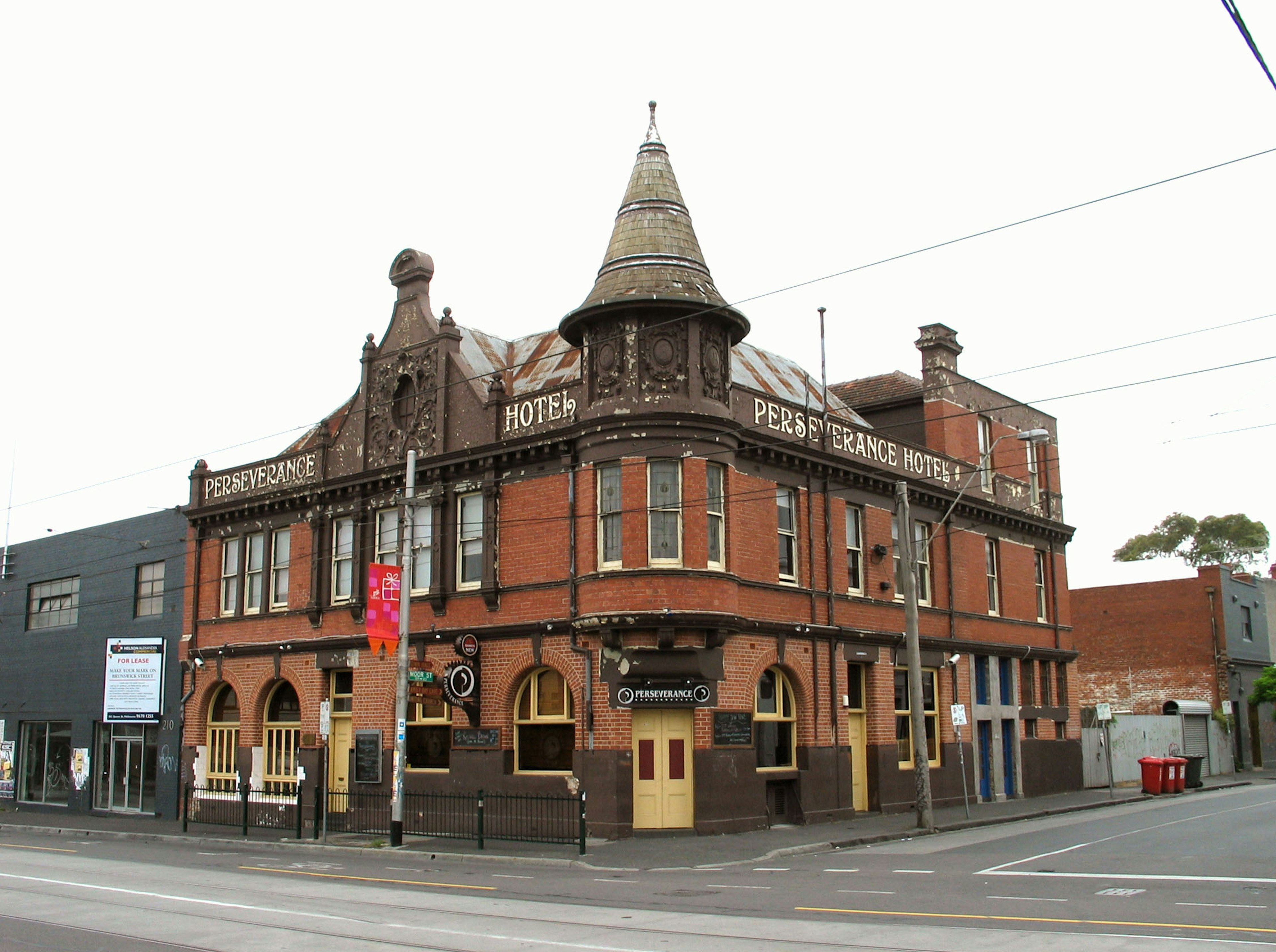 Historische Pub-Außenansicht mit roten Ziegeln und spitzem Turm