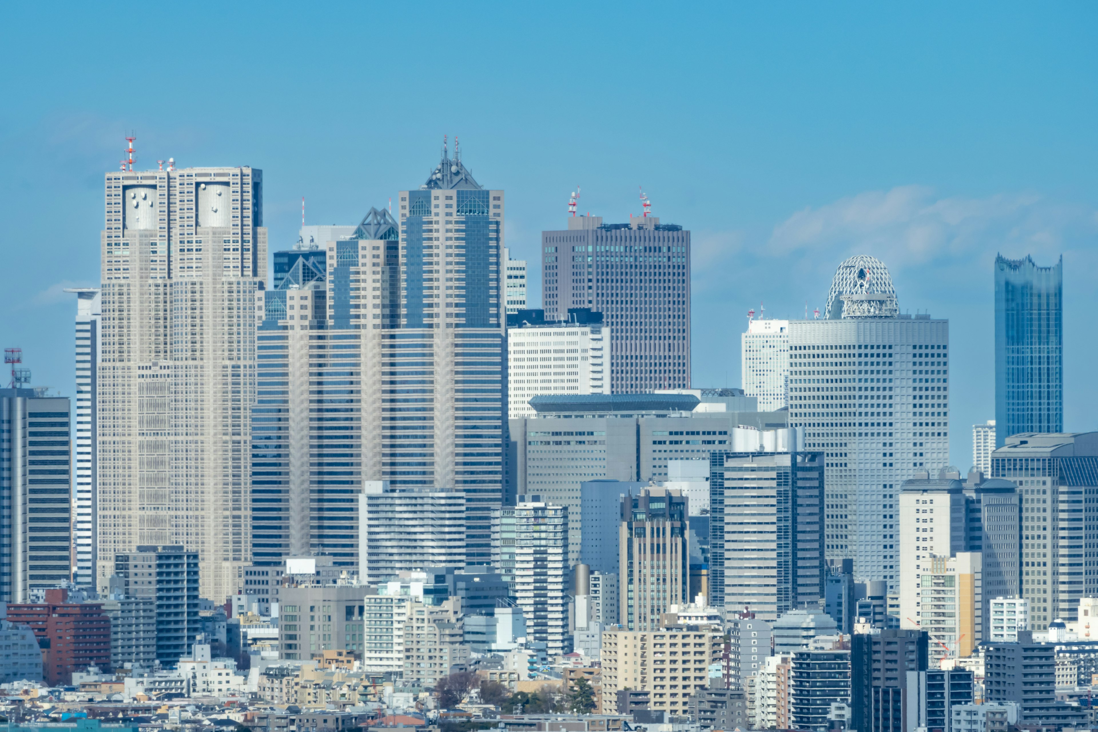 Tokyo skyline featuring modern skyscrapers under a blue sky