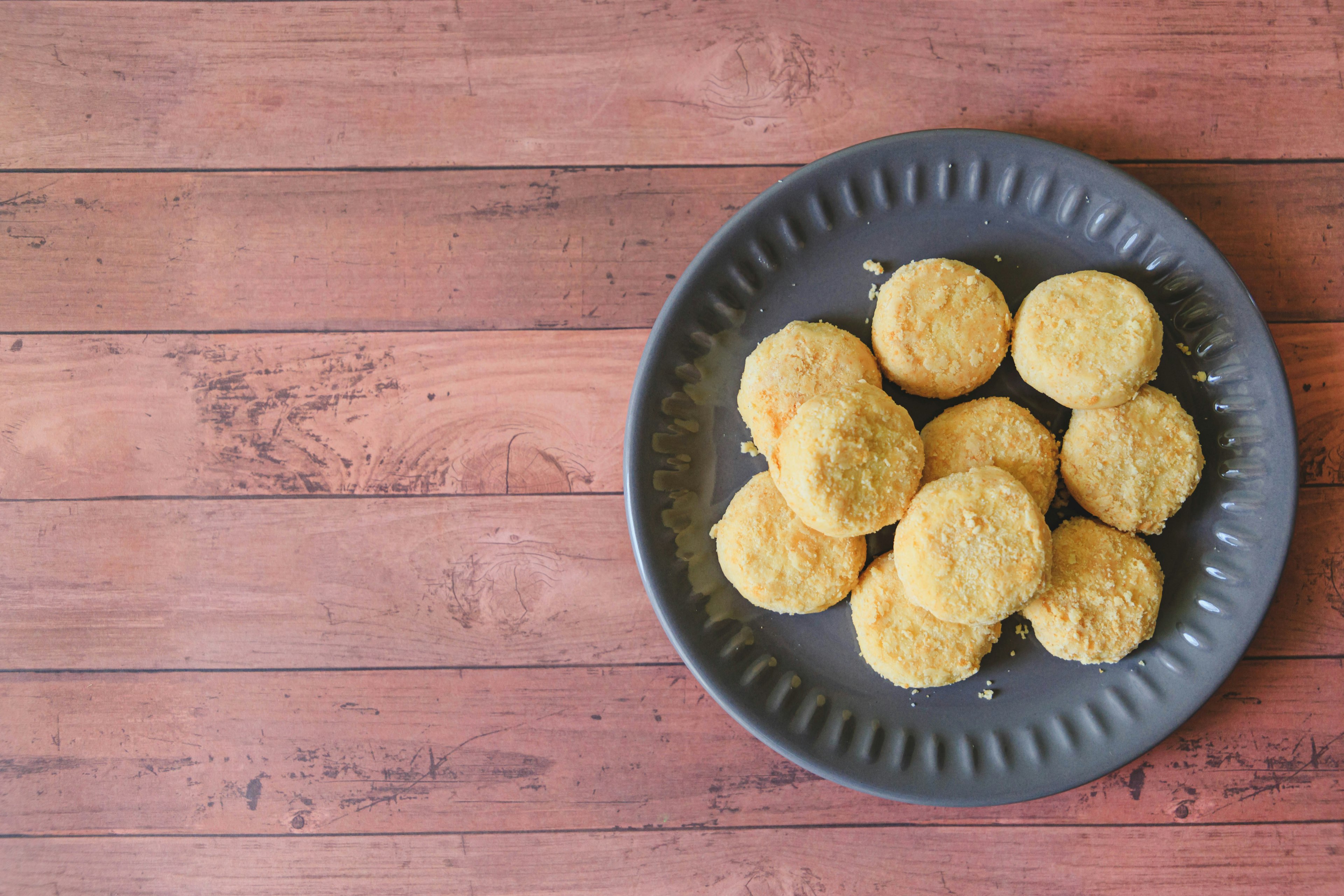 Galletas dispuestas en un plato negro sobre una superficie de madera