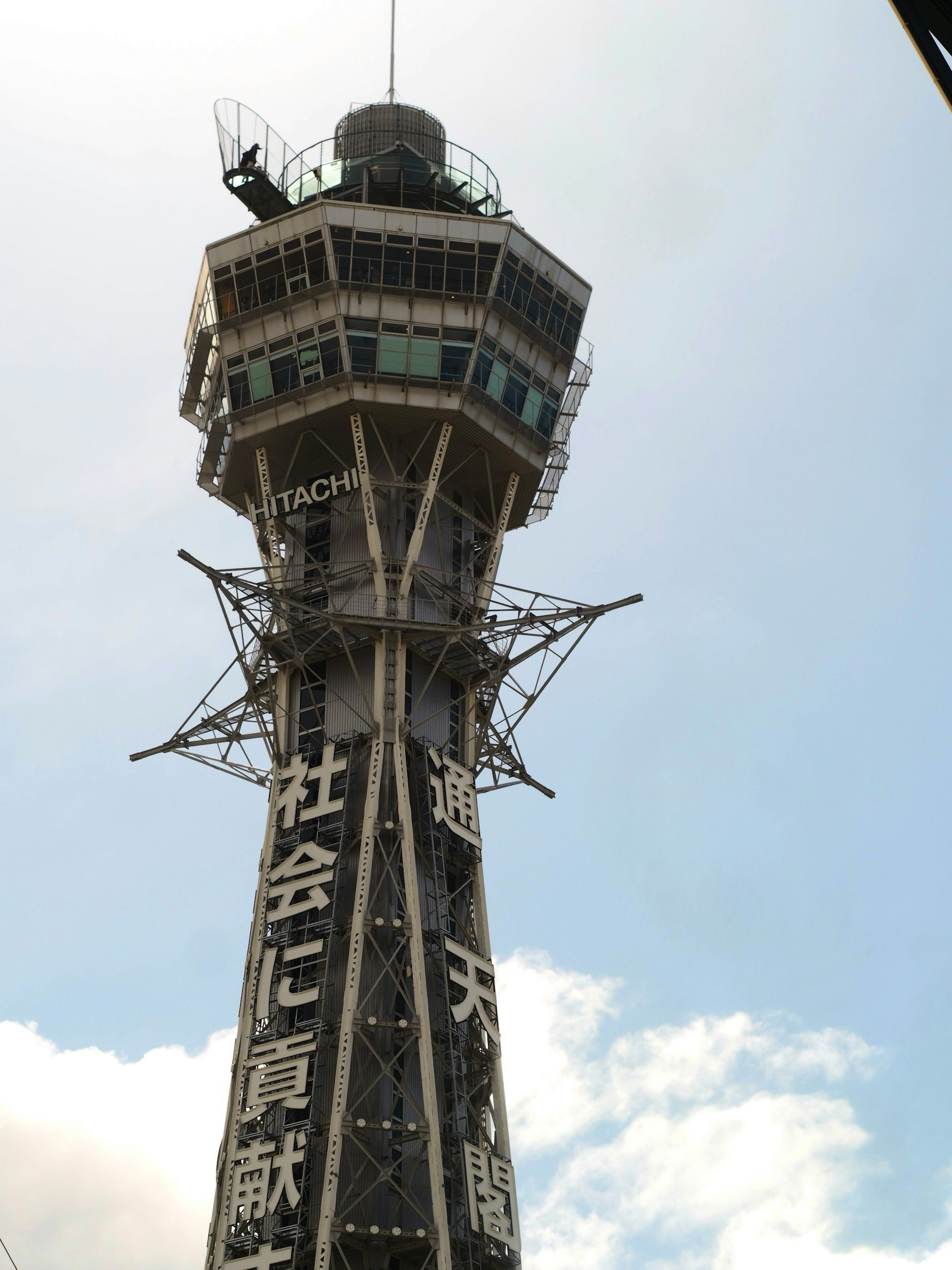 Gambar Menara Tsutenkaku di Shinsekai di bawah langit biru yang menampilkan landmark terkenal