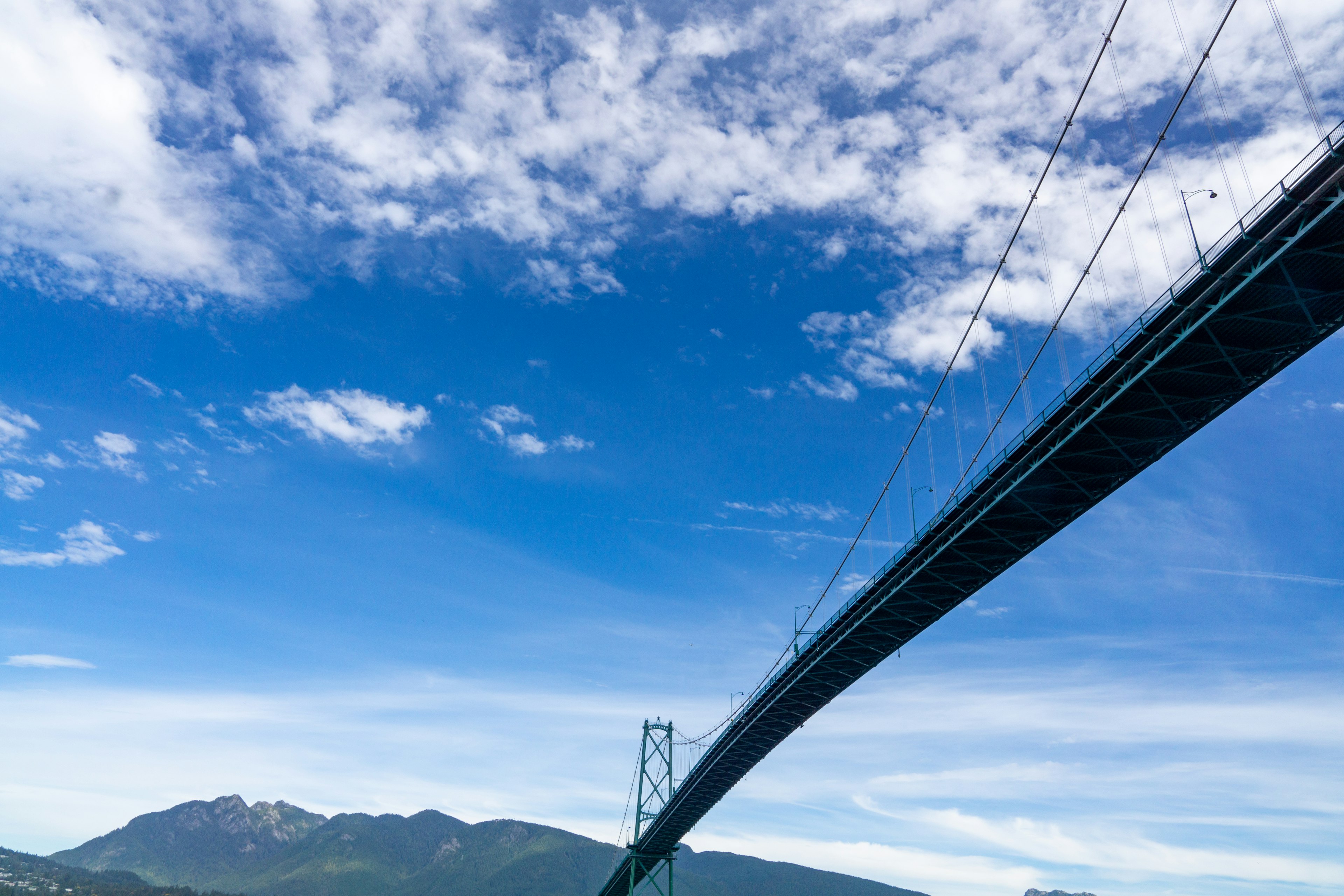 Eine Sicht auf eine Brücke unter einem blauen Himmel mit Bergen