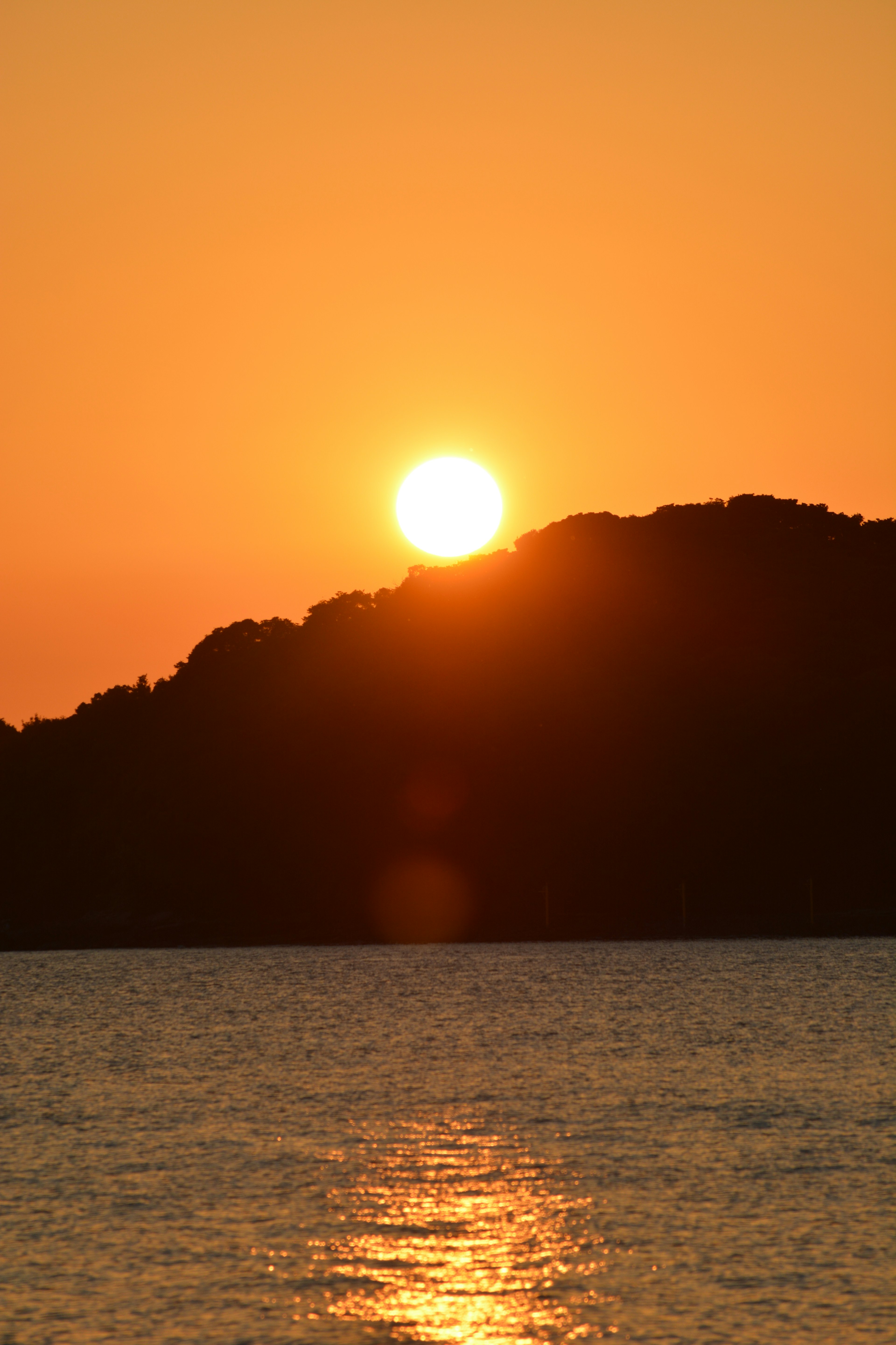 Magnifique coucher de soleil sur une colline avec de l'eau scintillante