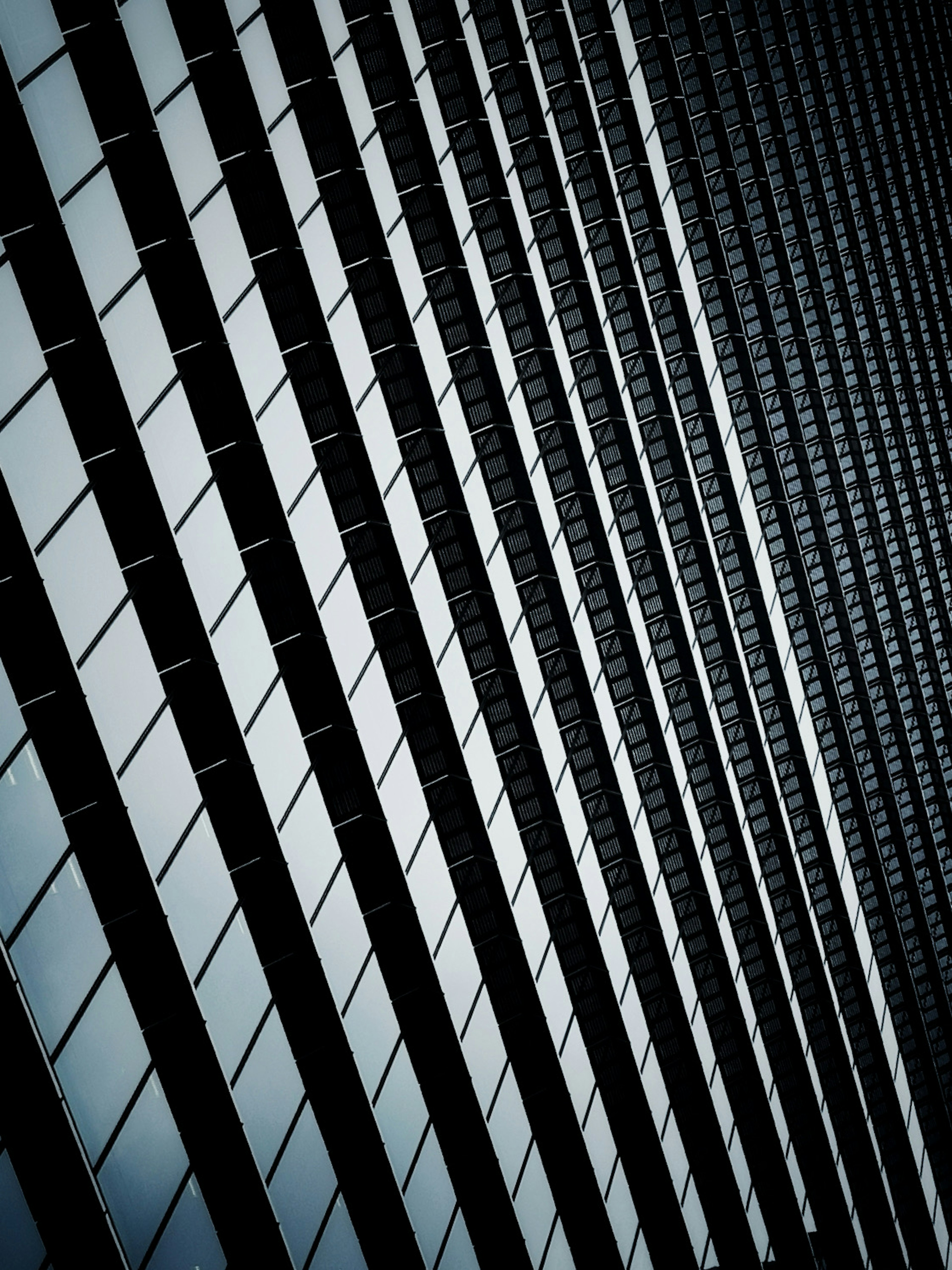 Diagonal glass panels of a building creating a layered effect