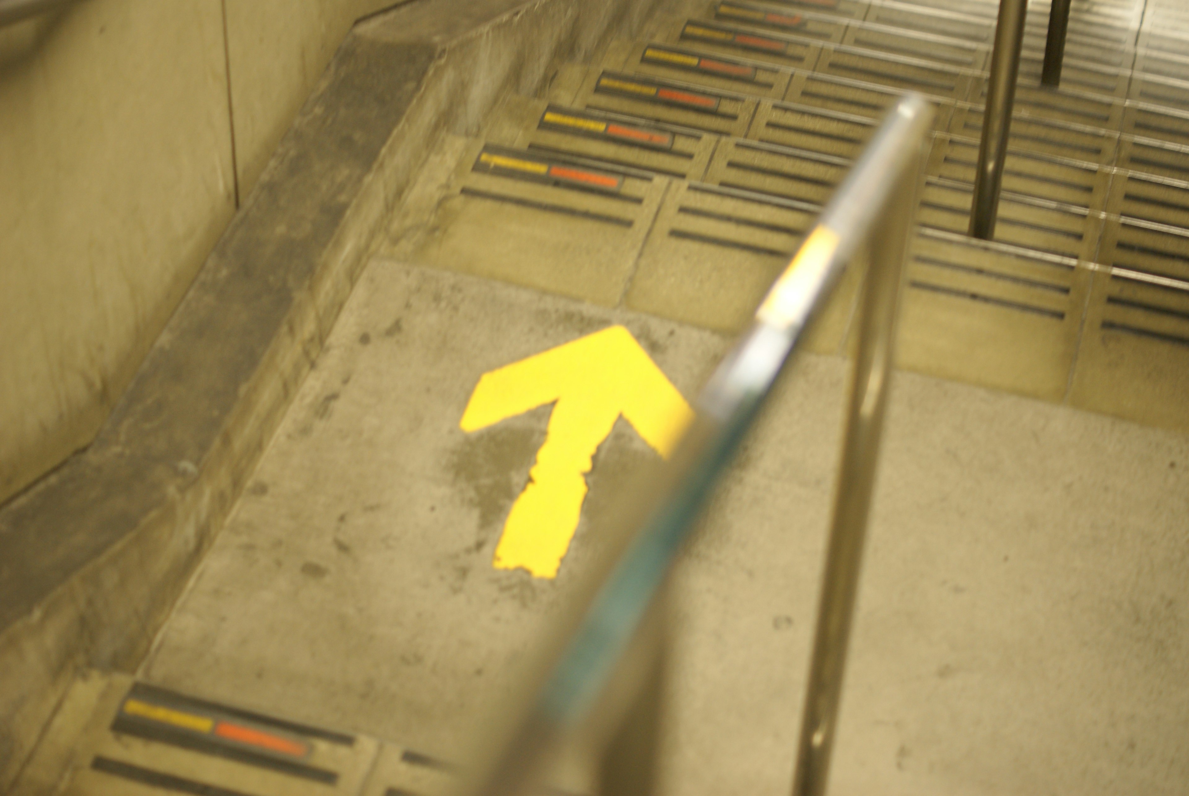 Yellow arrow pointing up at the base of a staircase