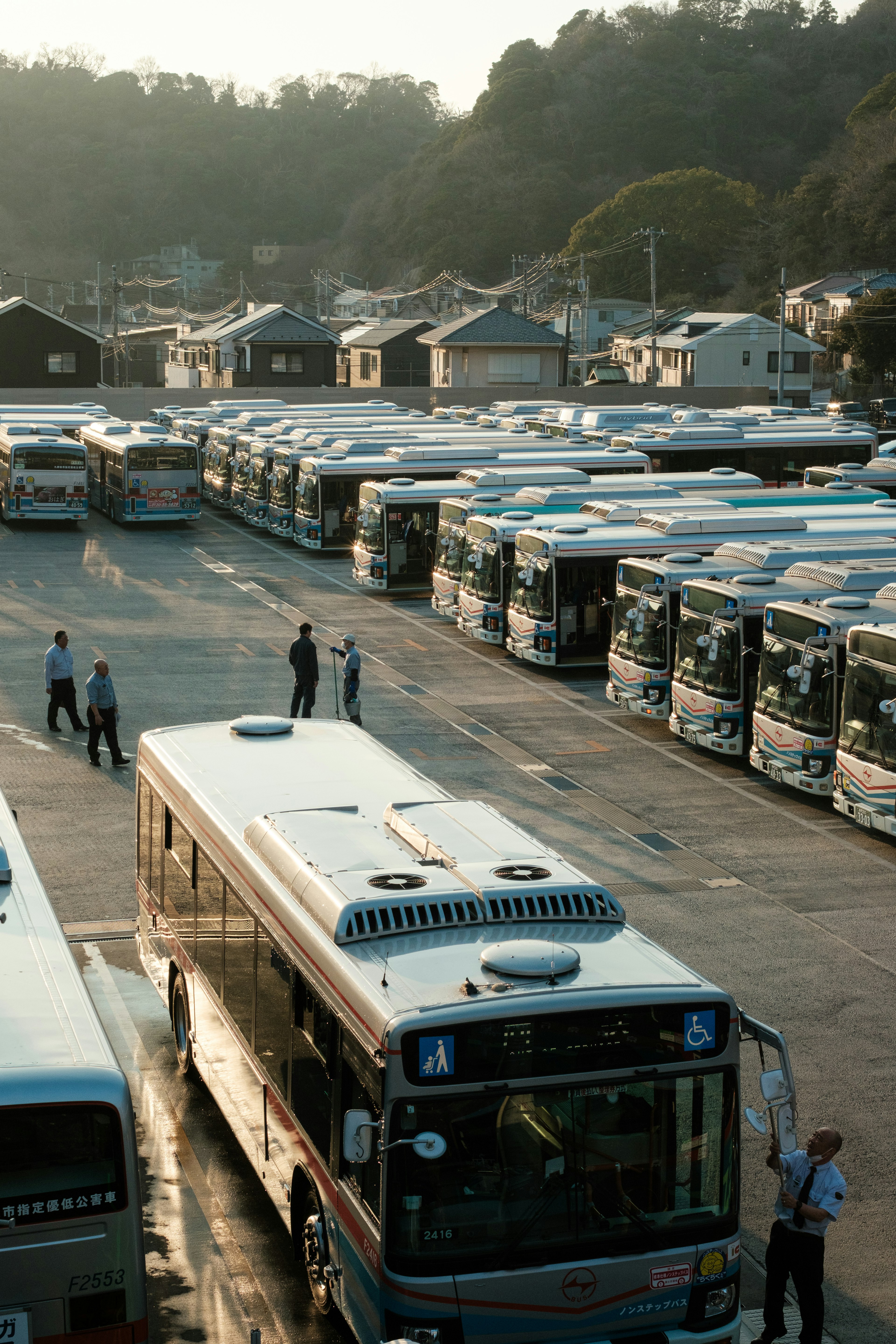 Aerial view of parked buses at a bus depot with people