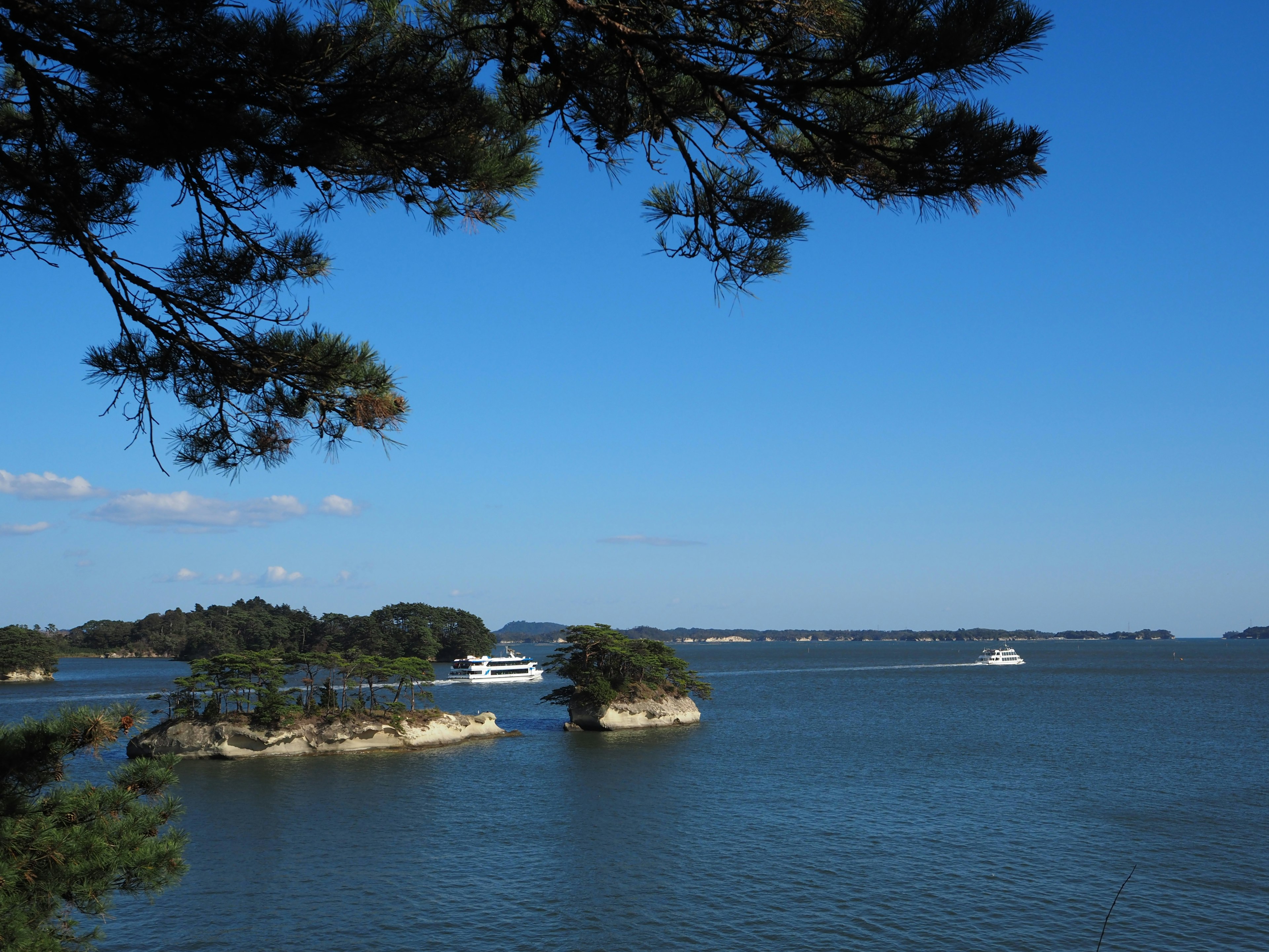 Vista panoramica di piccole isole e barche su acqua calma sotto un cielo blu