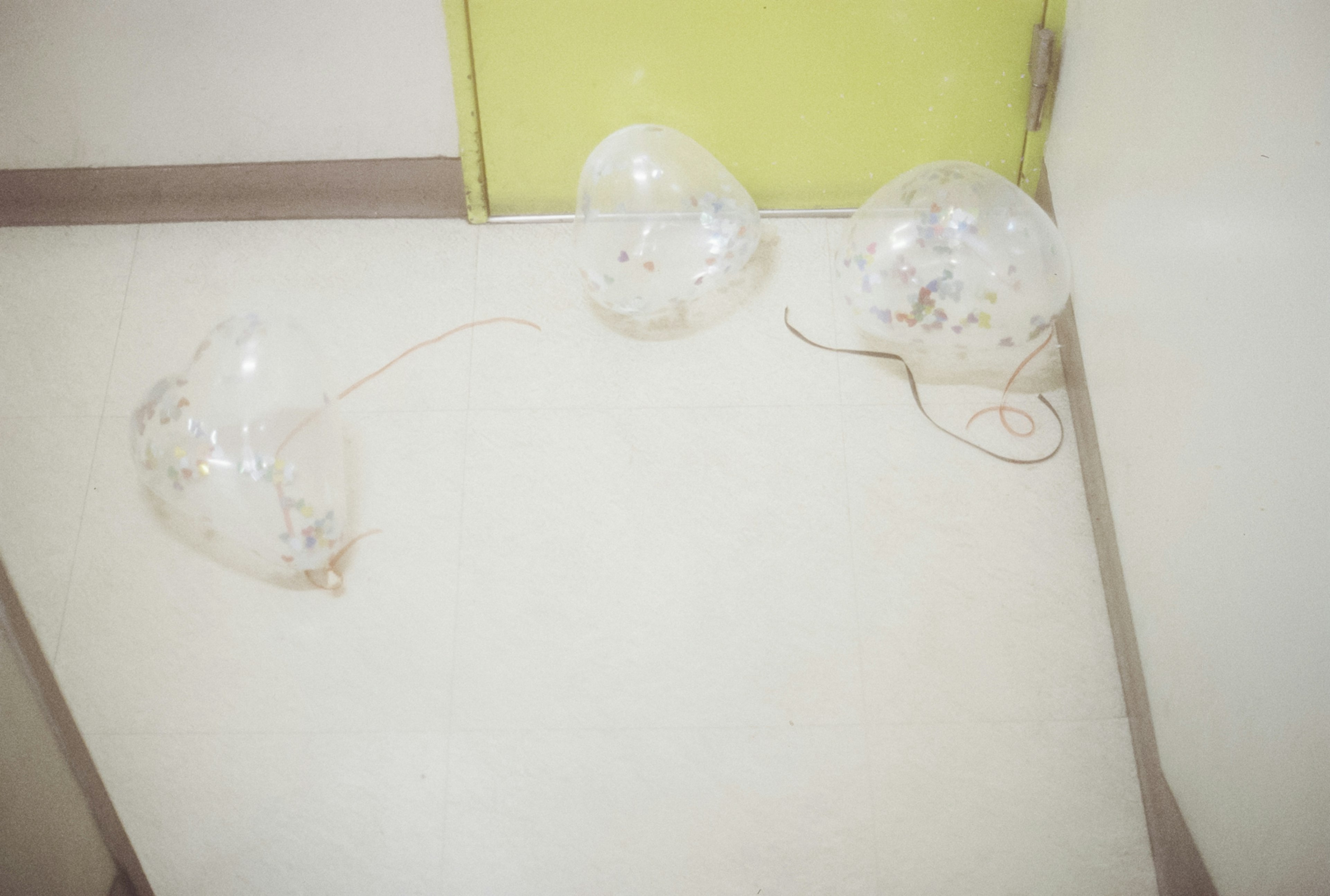 Three transparent balloons on a light-colored surface