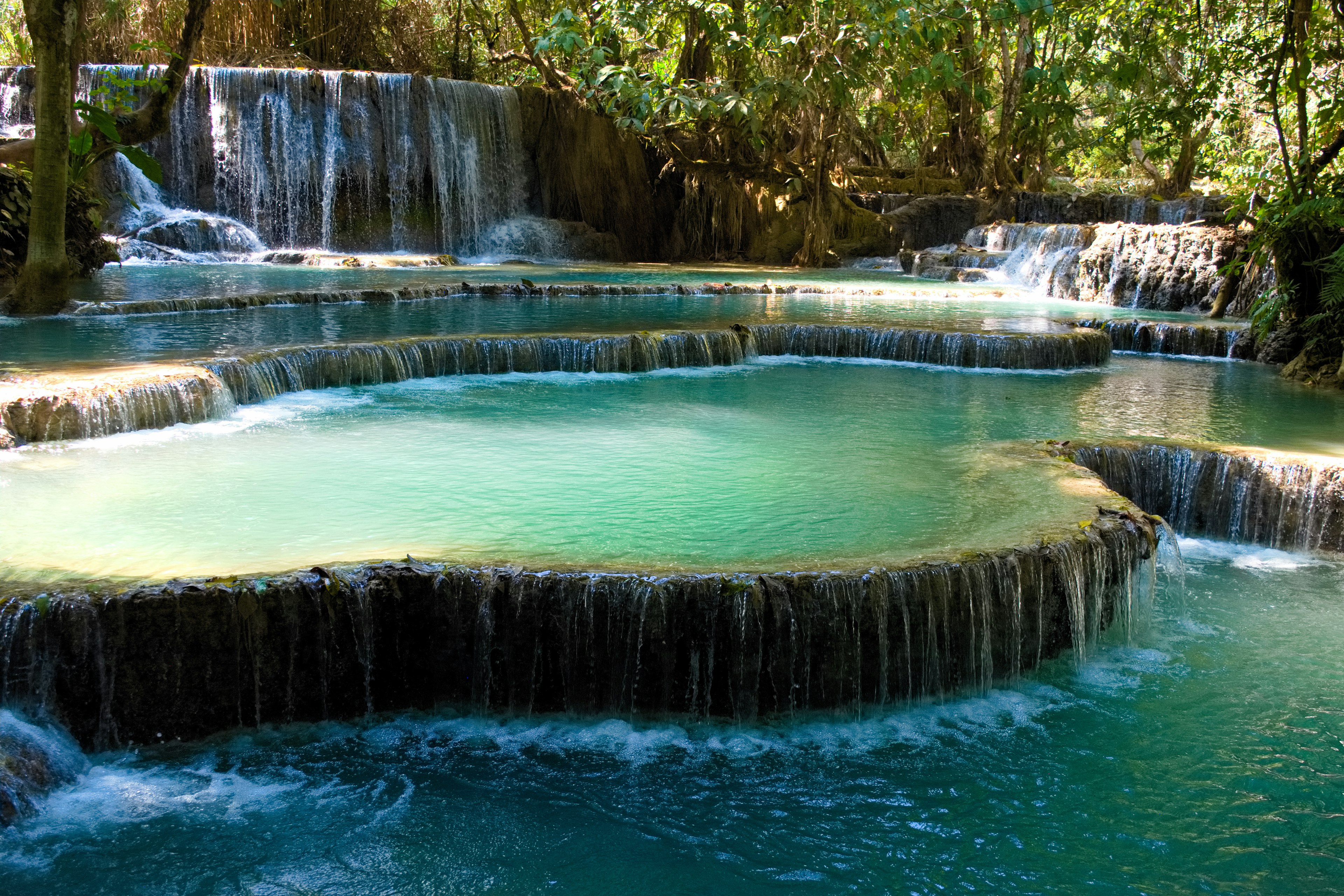 Emerald green waterfalls cascading into natural pools